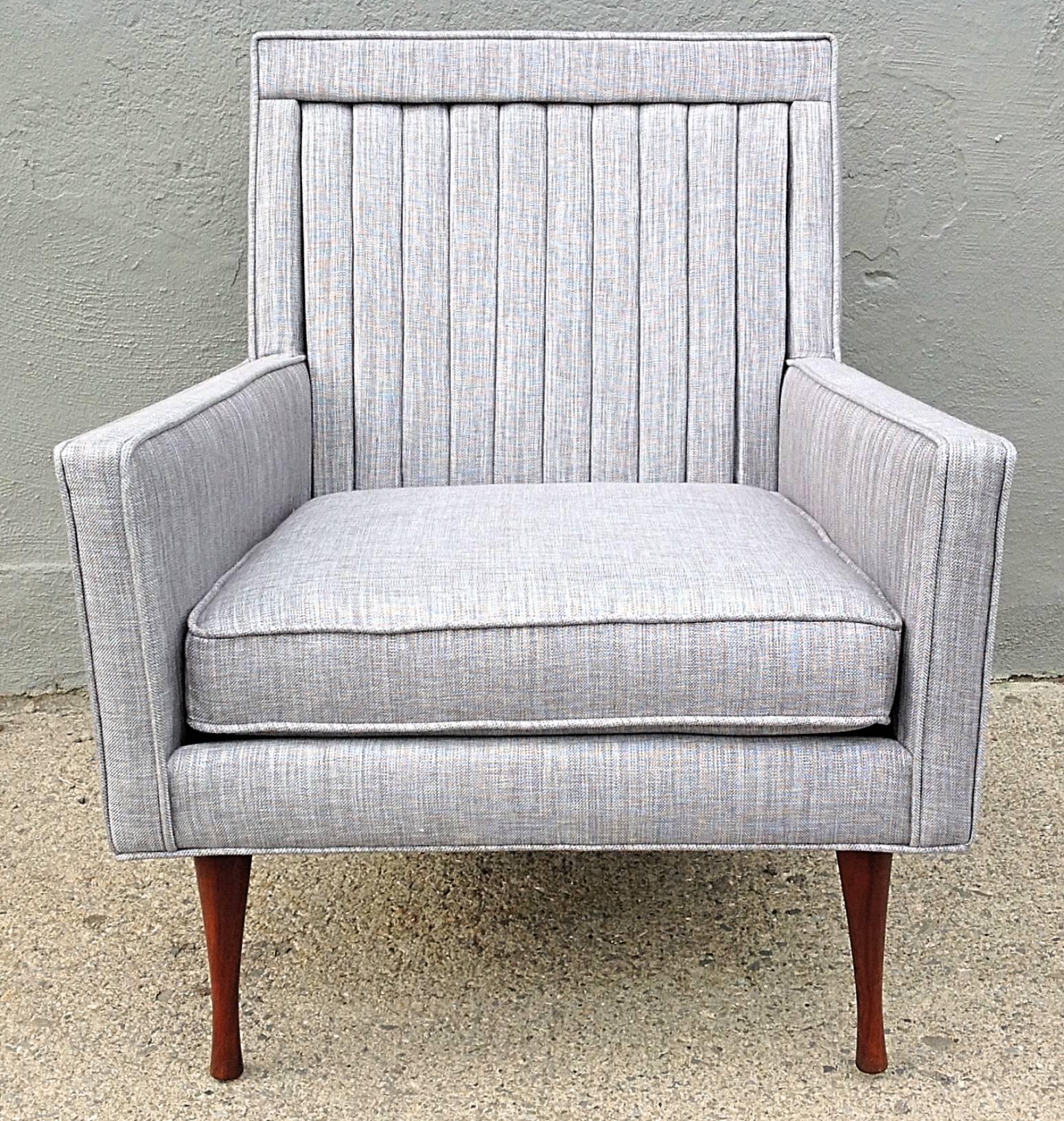 Channel back lounge chair with slim lines and sharp angles and walnut legs. Newly restored and reupholstered in a linen/cotton blend keeping the original integrity of the design. This chair is part of the Symmetric line designed by Paul McCobb for