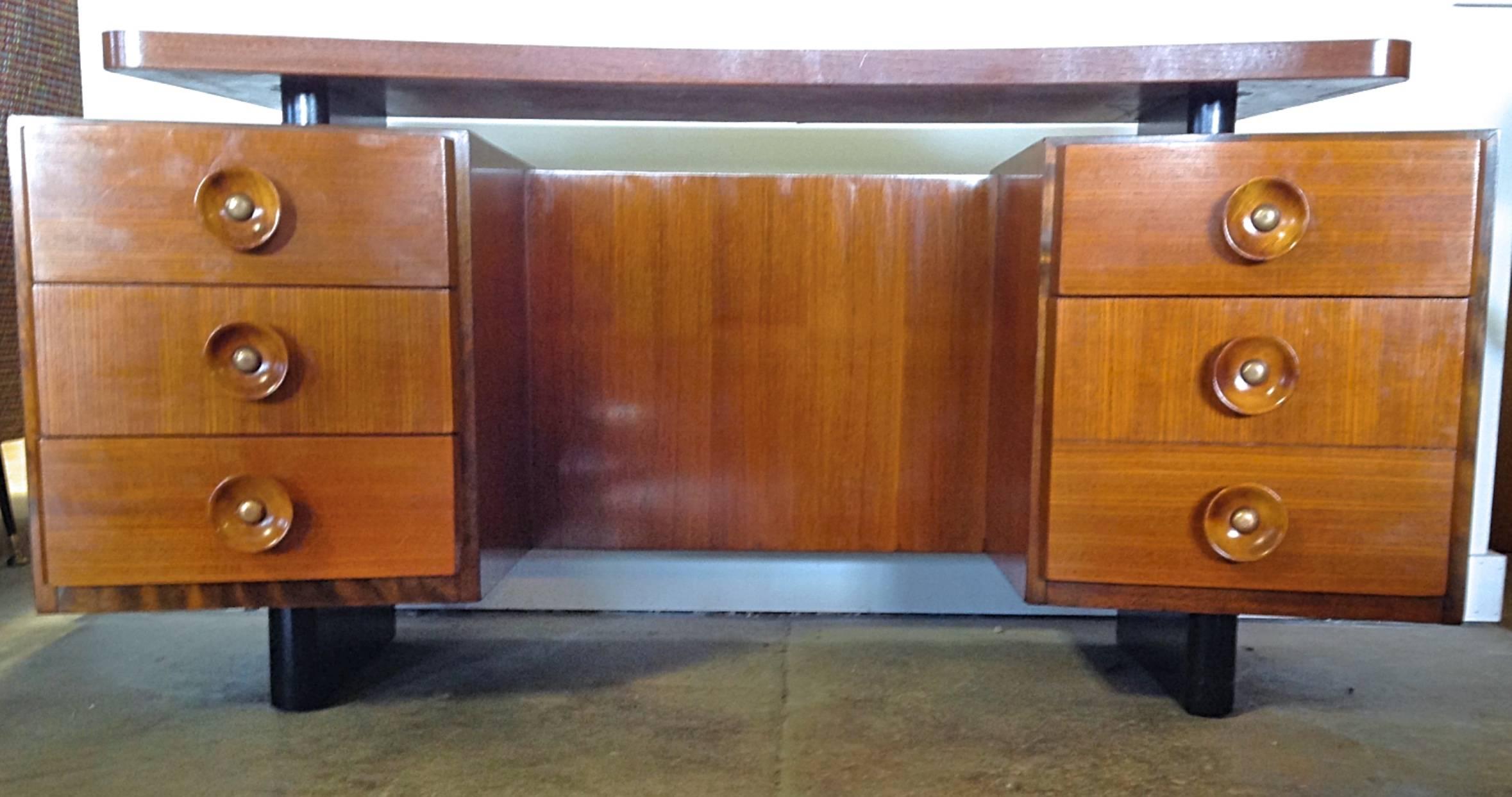 Model 4010 vanity in walnut and American ash designed by Gilbert Rohde for Herman Miller, 1940. Tone on tone with black accents and shaped floating top and angled drawers this piece is classic modernism at its best. Tastefully restored. This piece