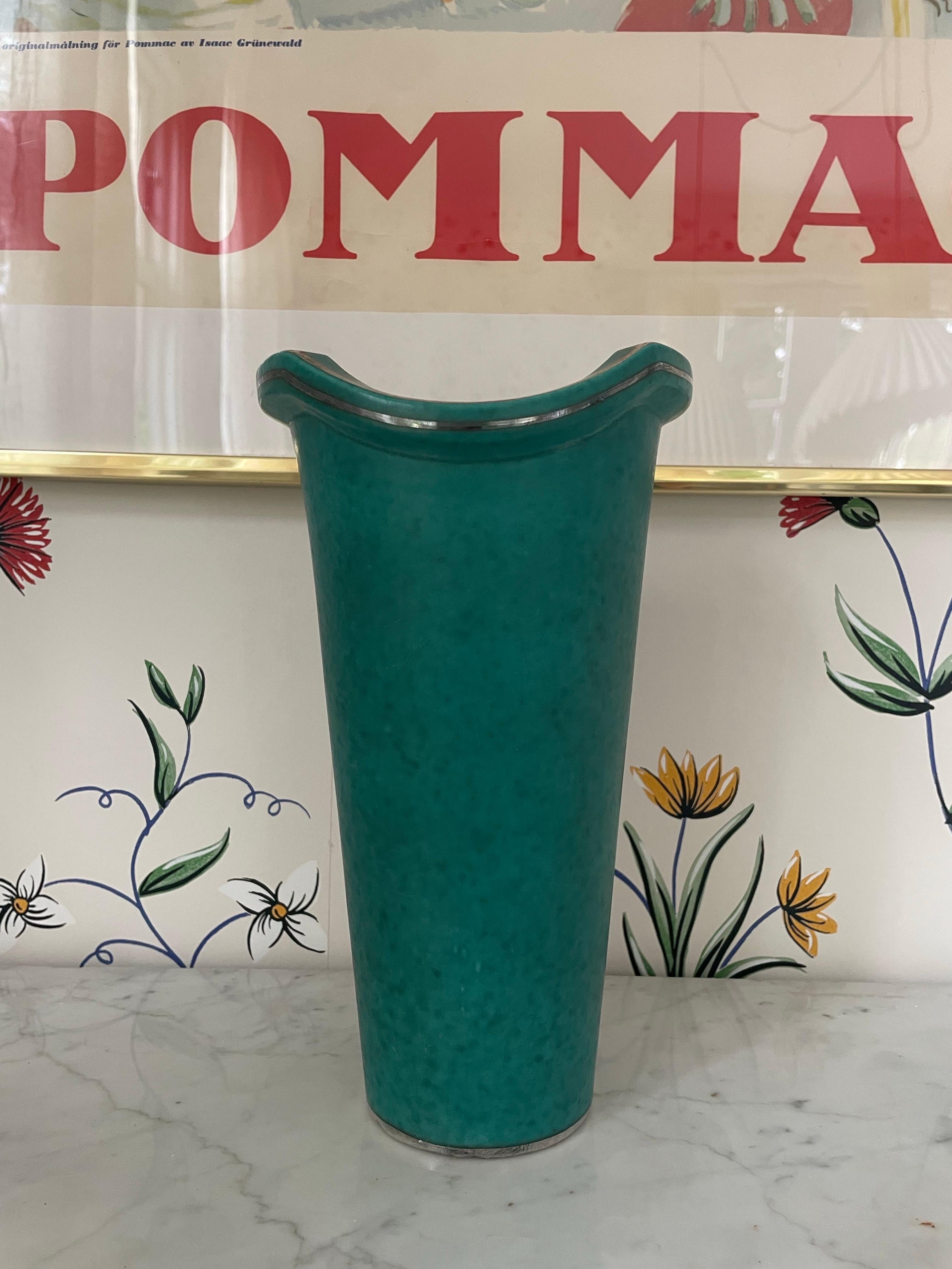 Élégant vase Art déco de la célèbre série Argenta, conçue par Wilhelm Kåge pour Gustavsberg en Suède dans les années 1930. Cette pièce présente le glaçage craquelé vert caractéristique, joliment rehaussé d'une couche d'argent représentant une