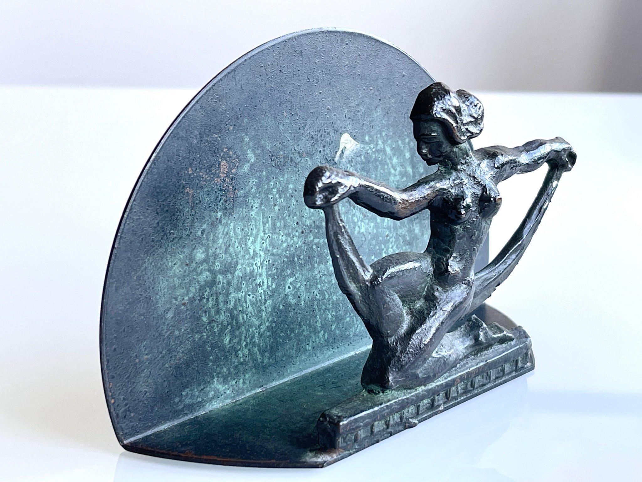 Un raro portatovaglioli svedese Art Deco degli anni '30, splendidamente fuso in bronzo, con una ballerina stilizzata nuda in una posa drammatica e arcuata. La figura è montata su uno sfondo di bronzo semicircolare, che esalta la silhouette scultorea