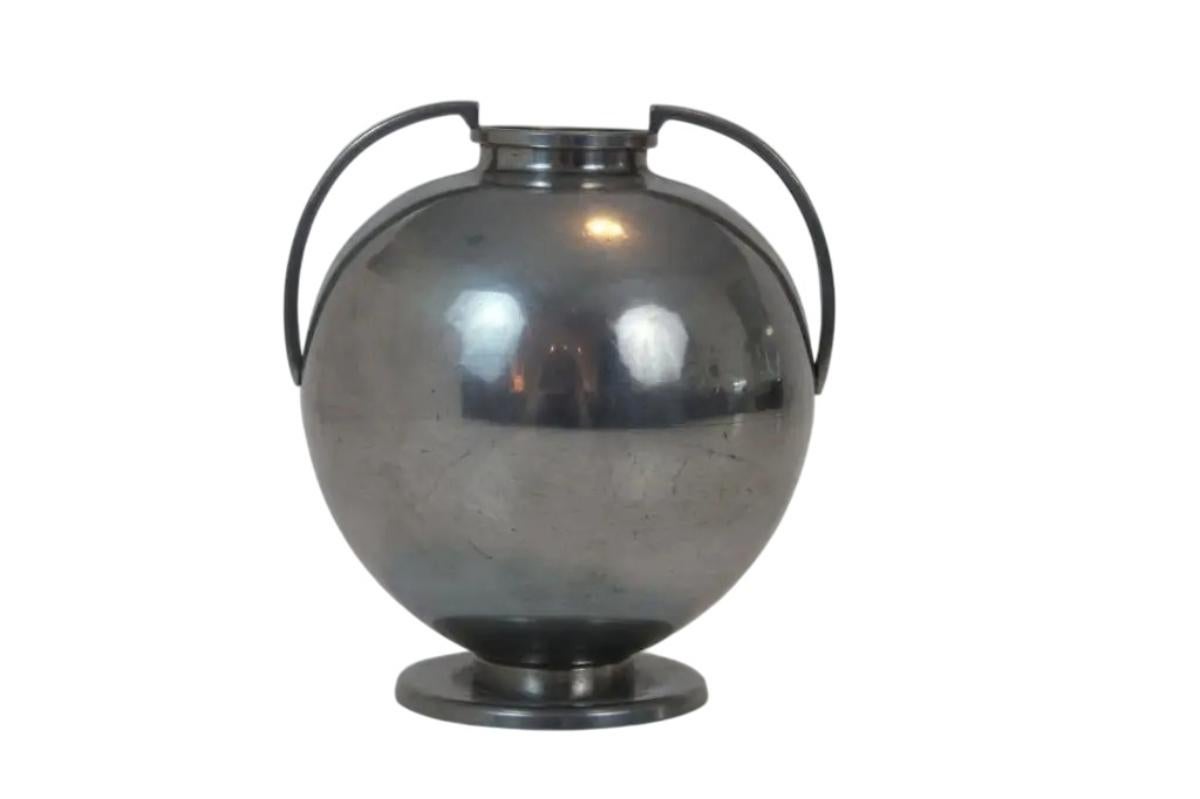 Progettato dal celebre designer industriale svedese Folke Arström per GAB Tenn, questo vaso scultoreo in peltro esemplifica l'eleganza del modernismo scandinavo. Datato 1937 (timbro GAB Tenn L8), il pezzo presenta un'armoniosa forma globulare,