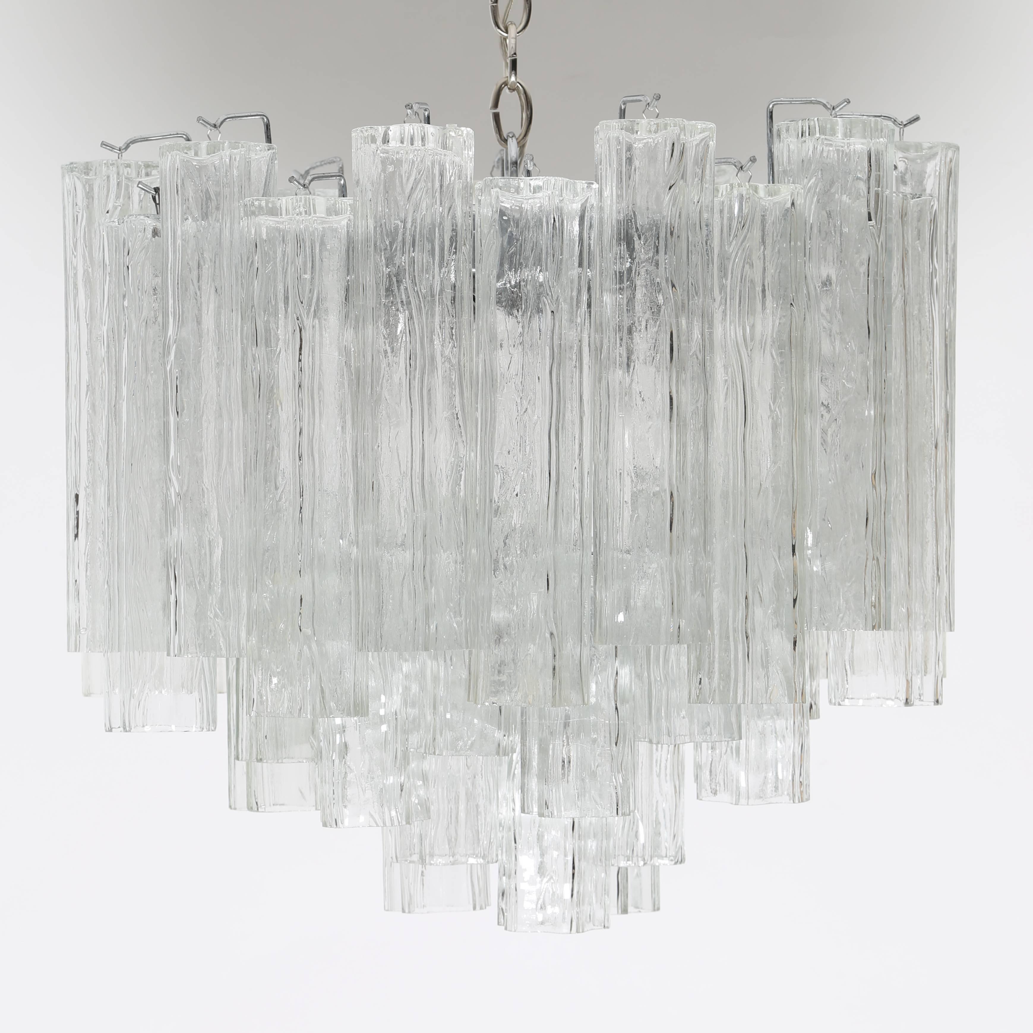 Gorgeous 1970s tiered chandelier densely packed with tronchi-shaped Murano crystals. Chrome frame holds 22 12" crystals and 20 6" crystals. Brightly lit by 16 candelabra-base bulbs. This item is in our Brooklyn showroom.