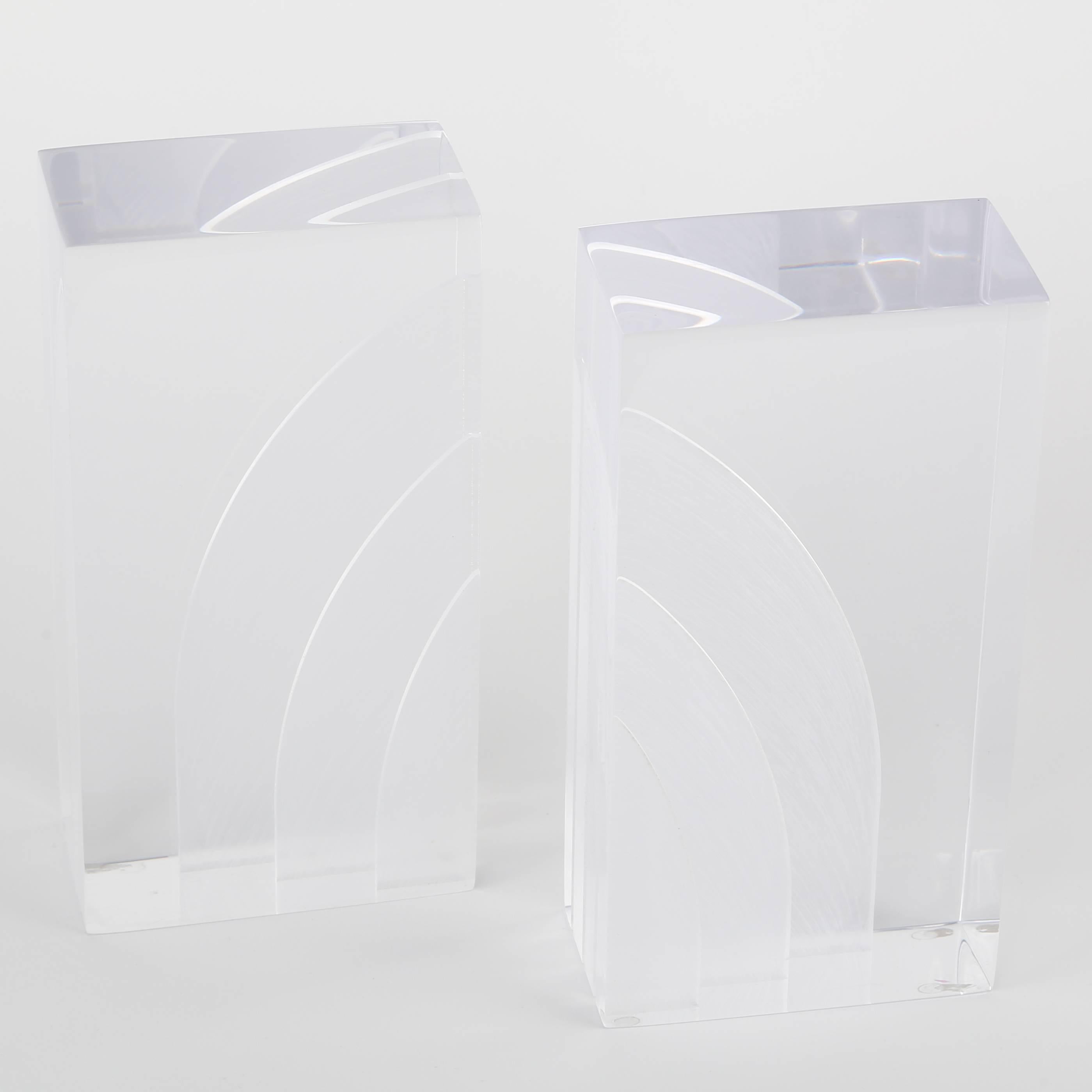 Graphic 1970s Lucite bookends with arched internal designs created by saw cuts, very unusual. These bookends are in our Brooklyn showroom.