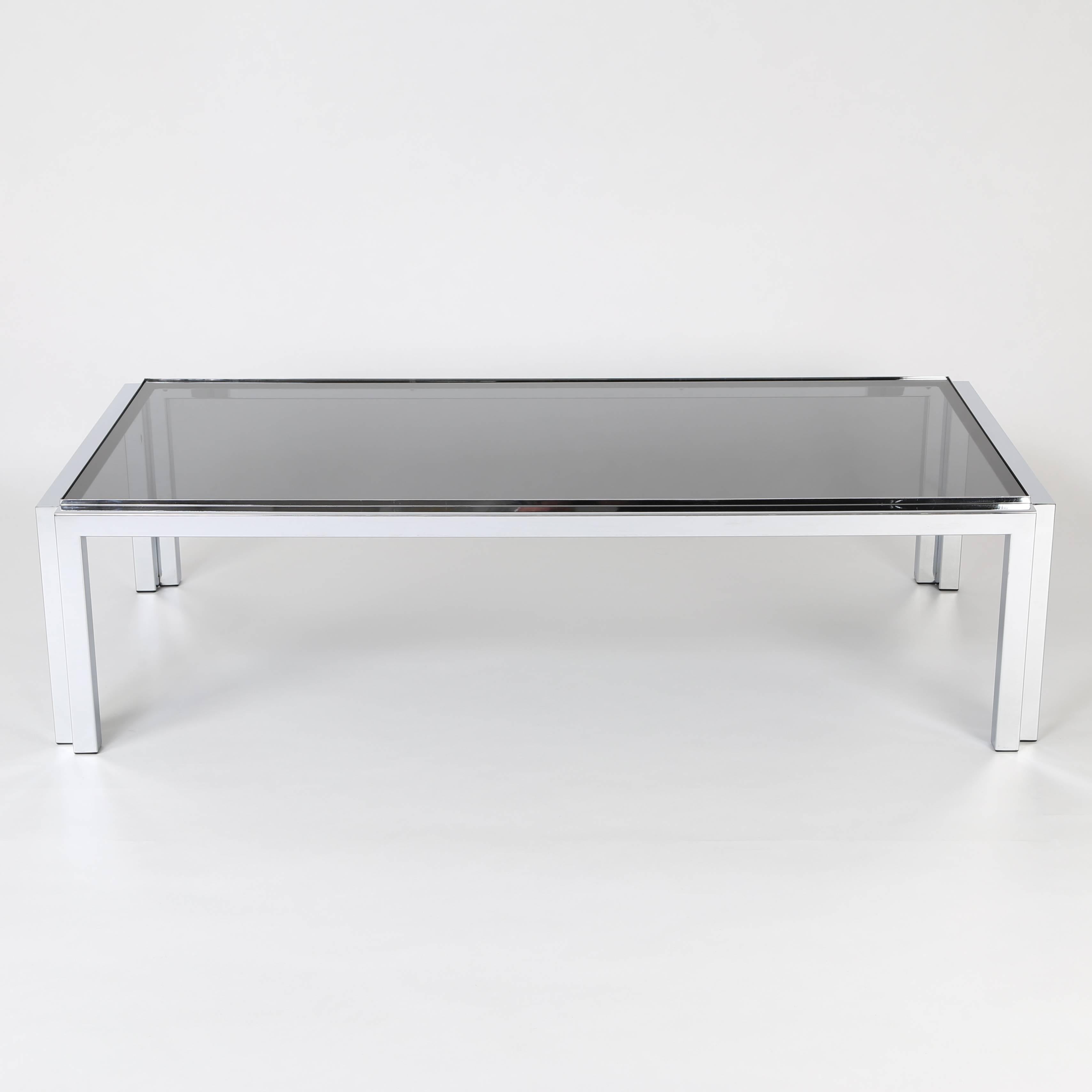 Large and sleek rectangular cocktail table features a square tubular chrome frame that supports an inset 3/8