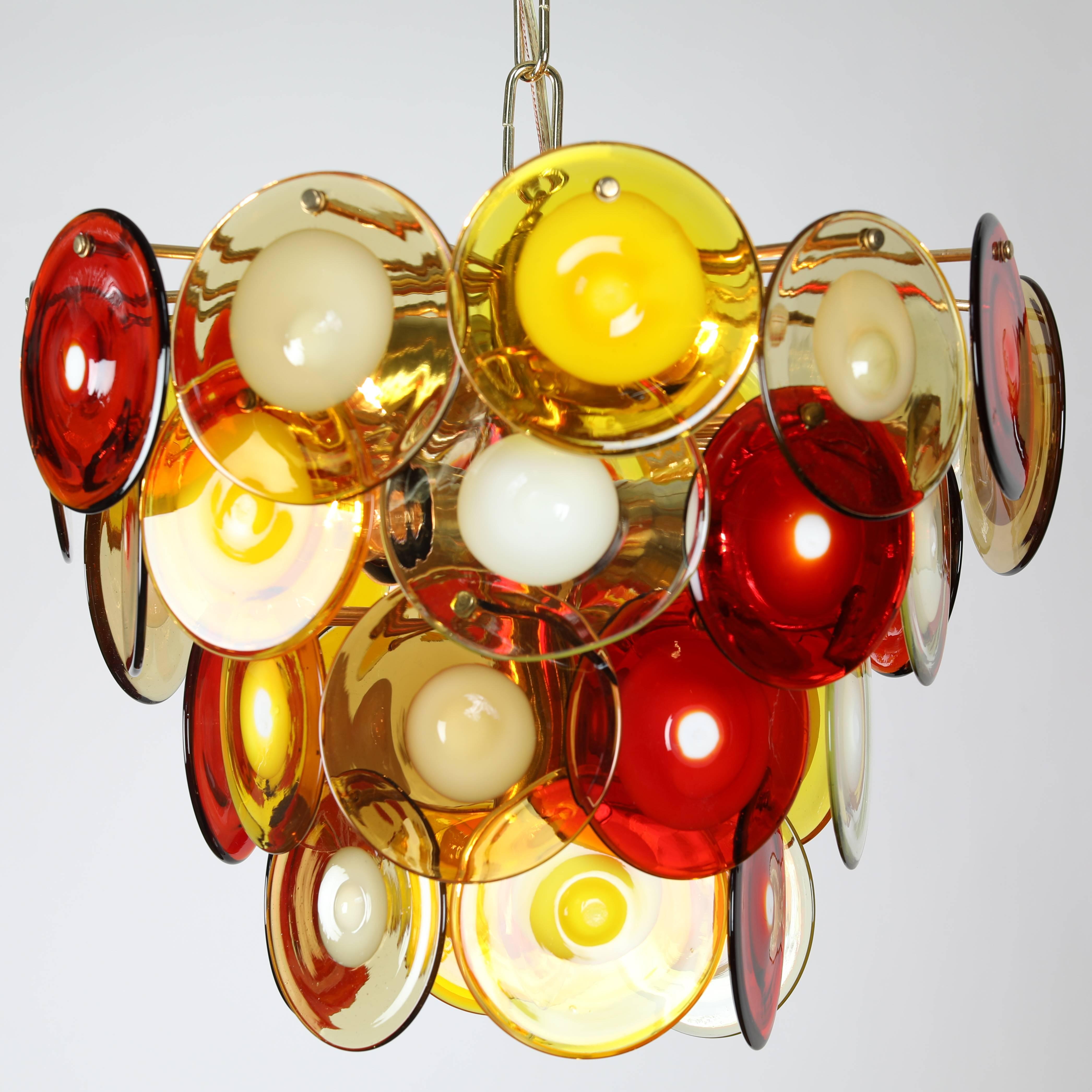 Colorful chandelier featuring 36 round hand-blown glass disks in red, yellow and white glass in a cascading formation. Takes four standard-base bulbs plus a single candelabra bulb. New wiring and sockets; new brass chain and canopy. 36