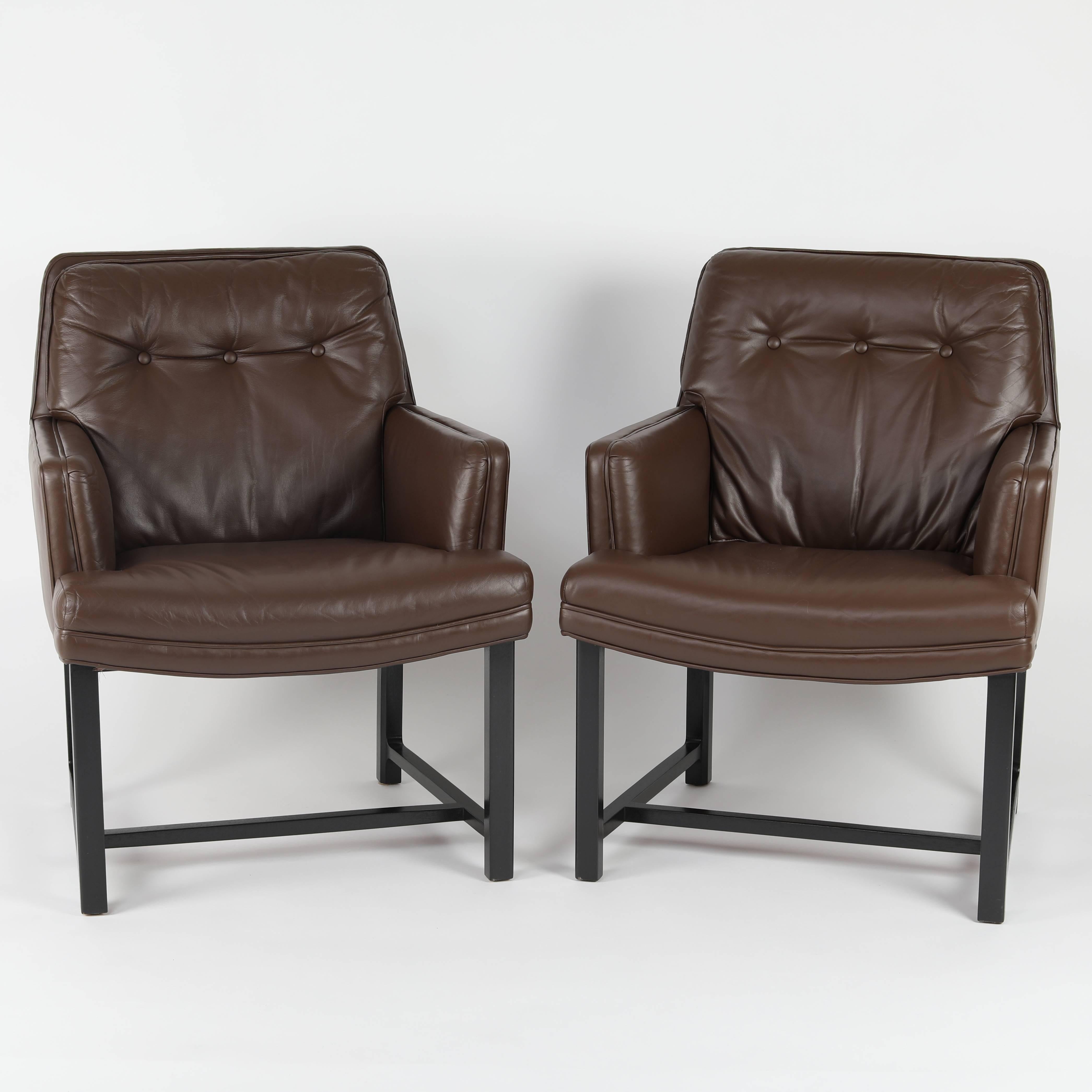 This fine pair of sturdy and versatile armchairs designed by Edward Wormley reflects Dunbar's signature high-quality construction. The wood frames have been professionally refinished and the original brown leather has been professionally restored.