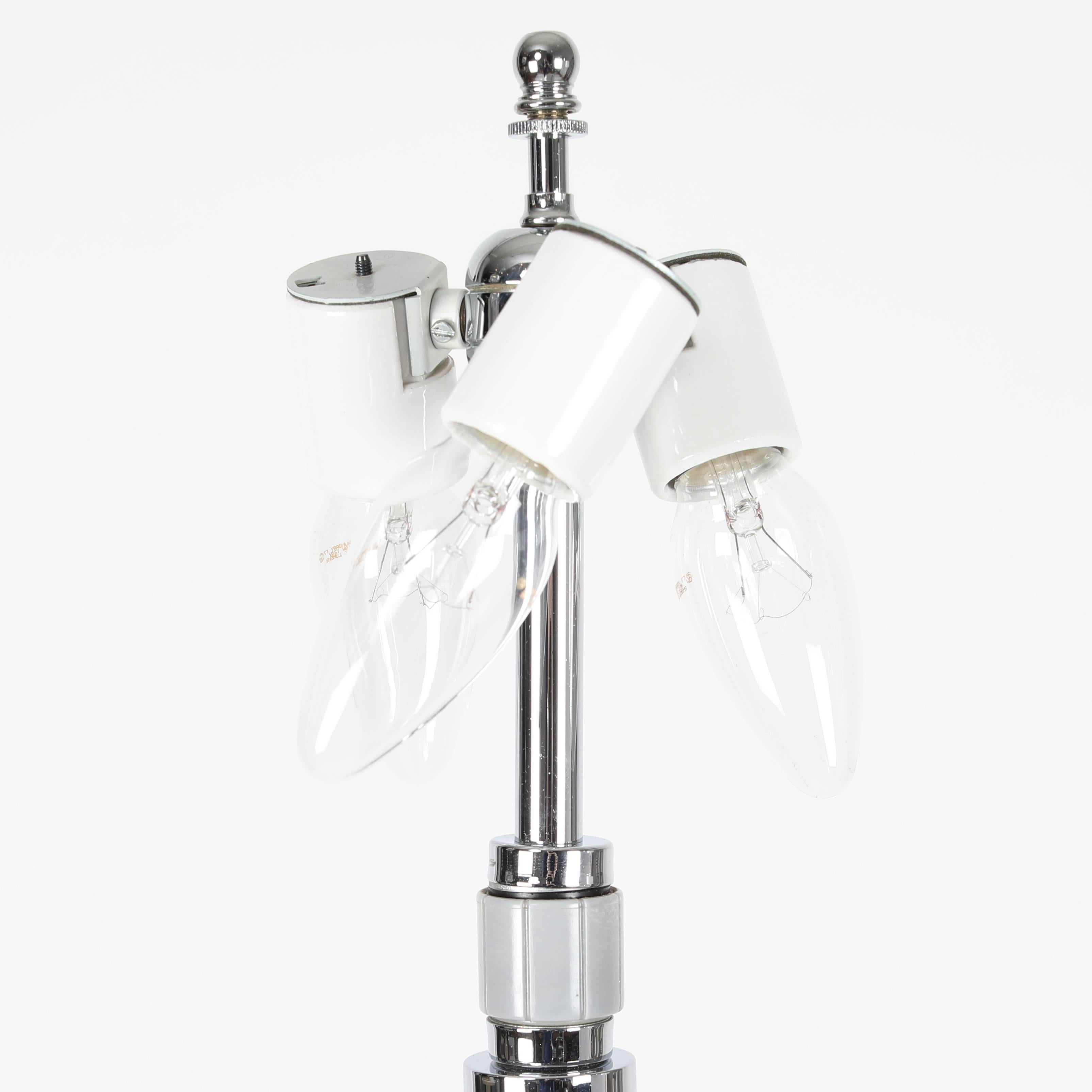 These simple and beautifully constructed floor lamps feature a single glass stem anchored by a square, weighted chrome base. Each lamp takes three standard-base bulbs. Plastic cuff on neck acts as a three-way switch and rotates to turn on one bulb,