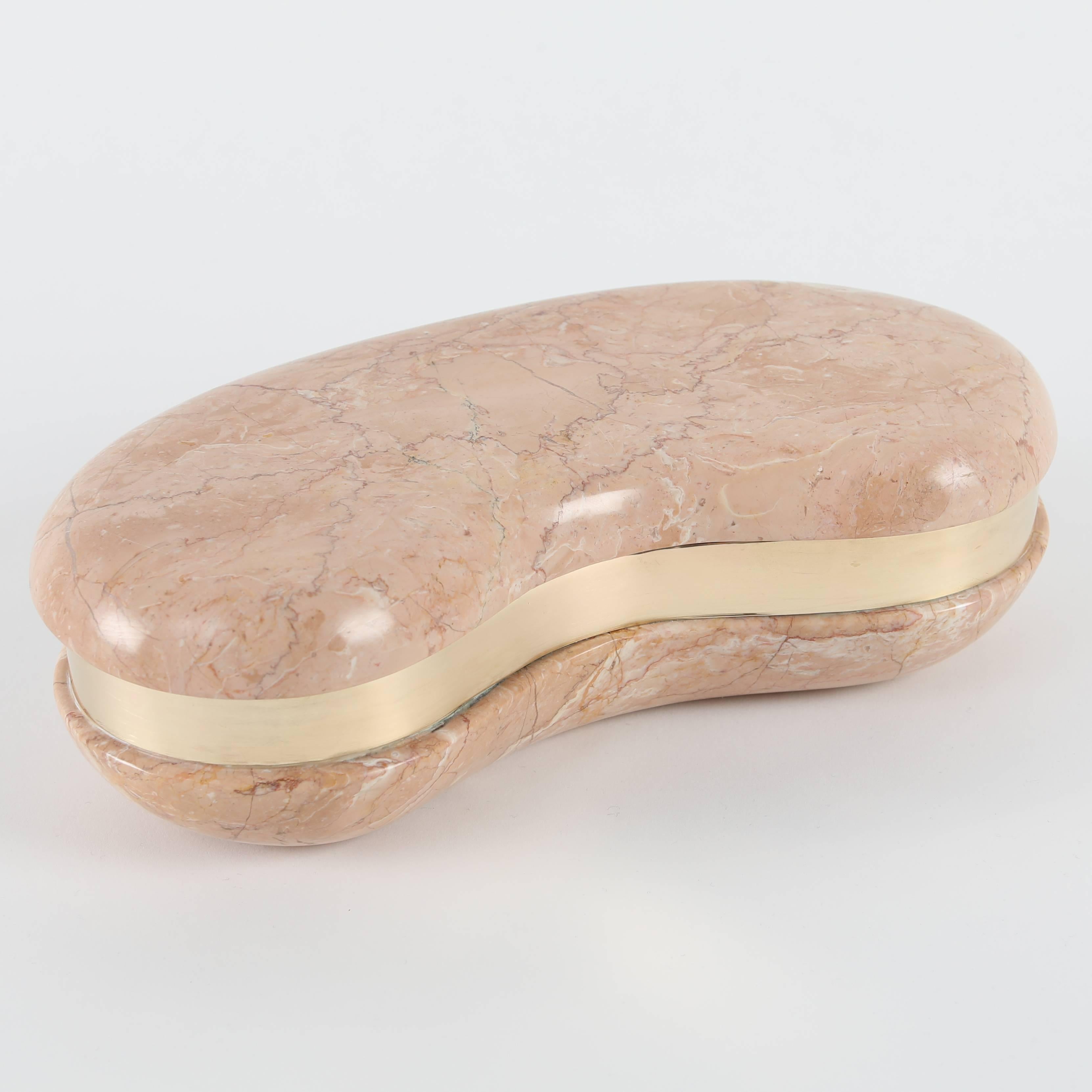 Chic kidney-shaped box made of carved pink marble with brass trim. Free-floating top fits snugly on base. Perfect for bedside table, dressing room, or as part of a table scape. 
