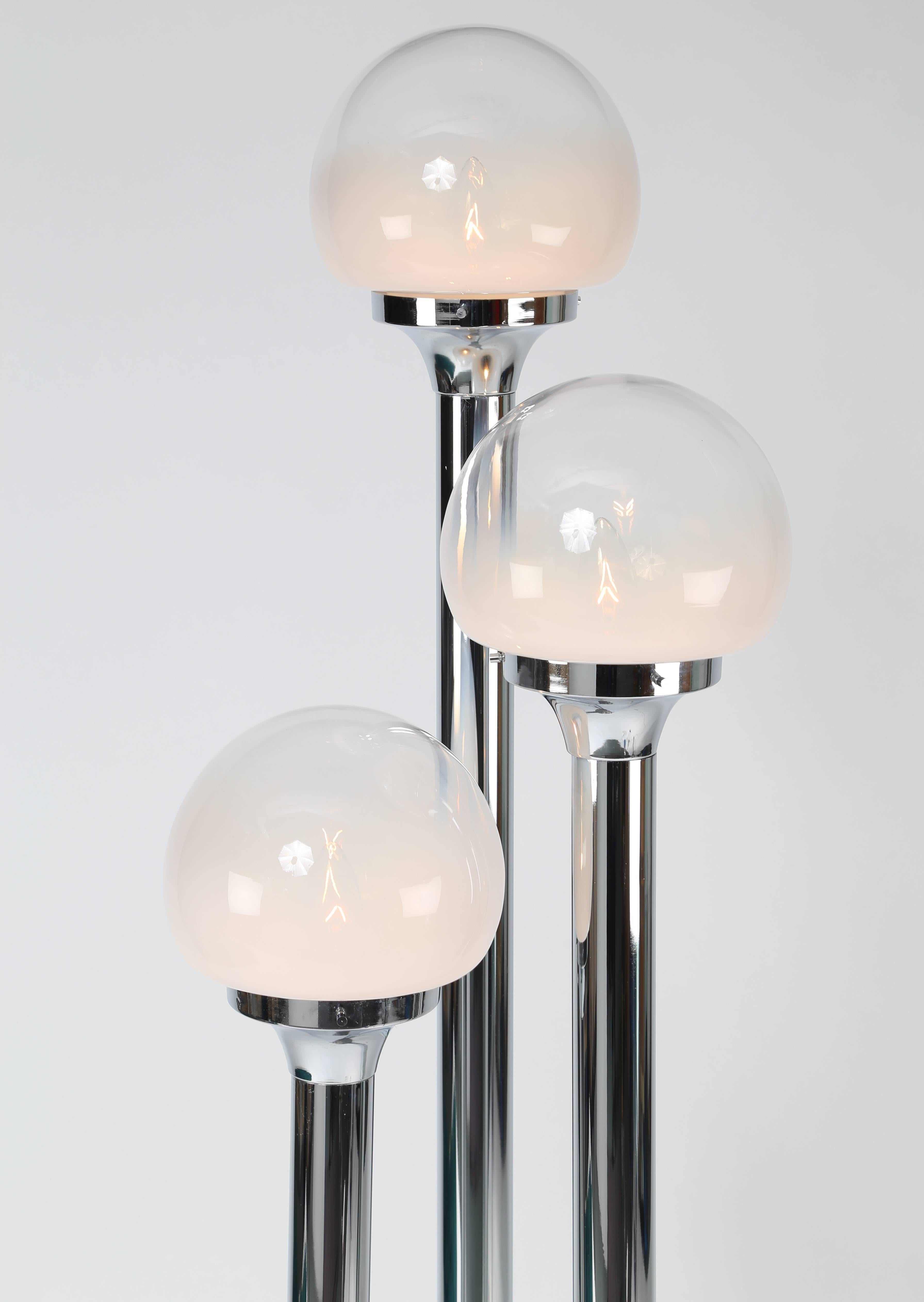 Polished-chrome floor lamp with three tubular supports, each holding a Murano-glass globe that is solid white at base graduating to clear at the top, circa 1970s. Overall dimensions including globes 11.5