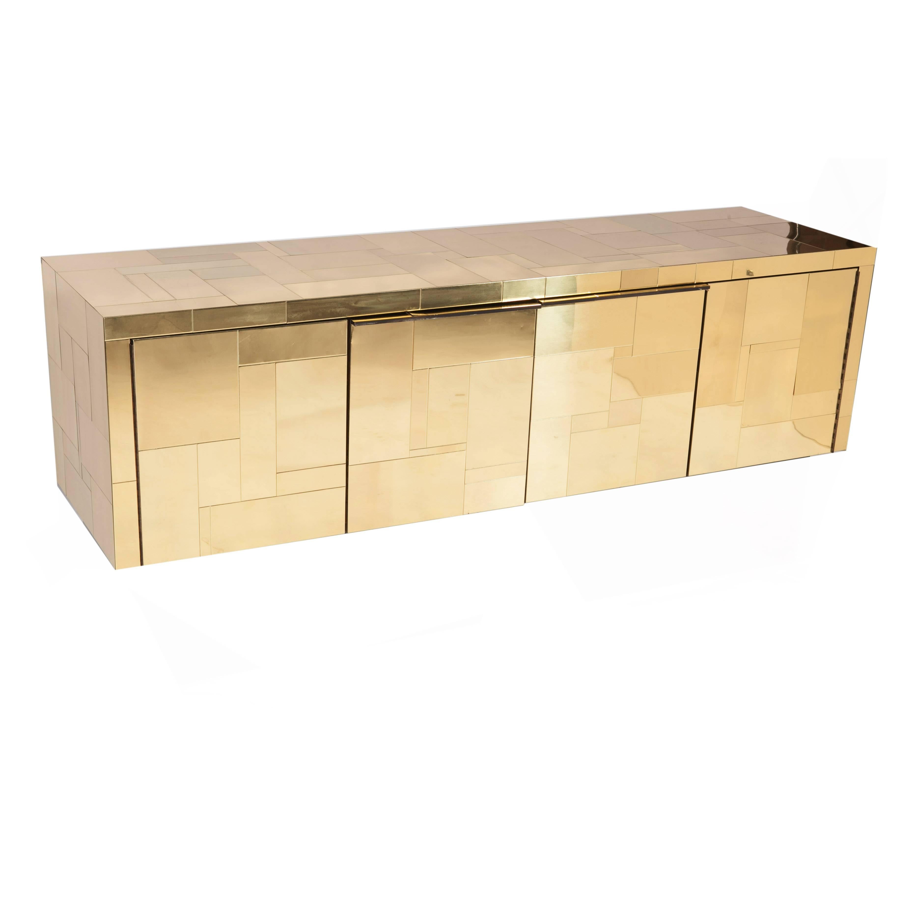 Super-chic, brass-tiled sideboard has two bi-folding doors that open to reveal a single drawer on the left side and a shelf on the right side. Black laminate interior. A beautiful example of Cityscape. 