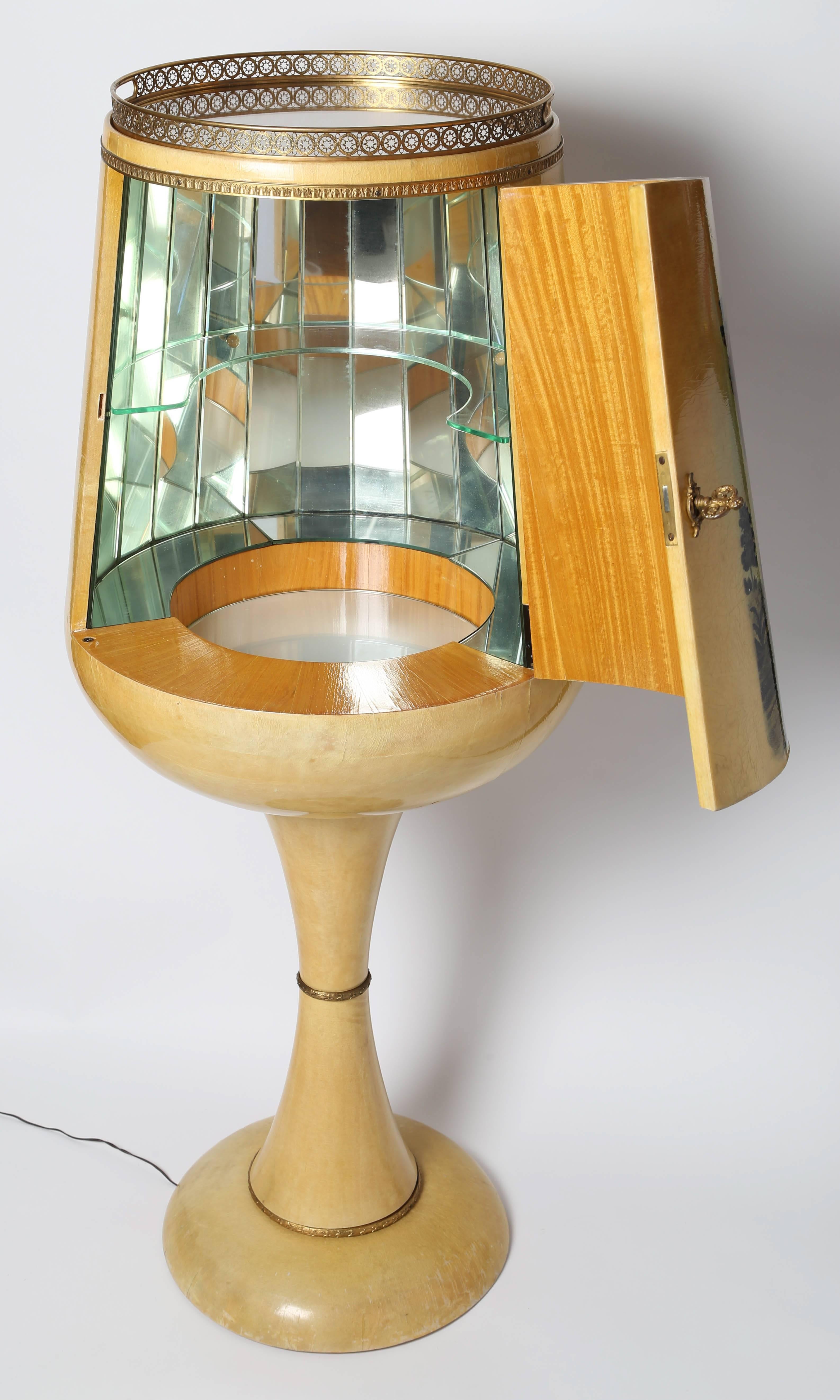 Whimsical 1950s Aldo Tura dry bar shaped like a goblet opens to reveal a faceted, mirrored interior, a single glass shelf and an illuminated frosted-glass bottom. Beautifully made with ornate solid-brass trim, hinges, original key and removable
