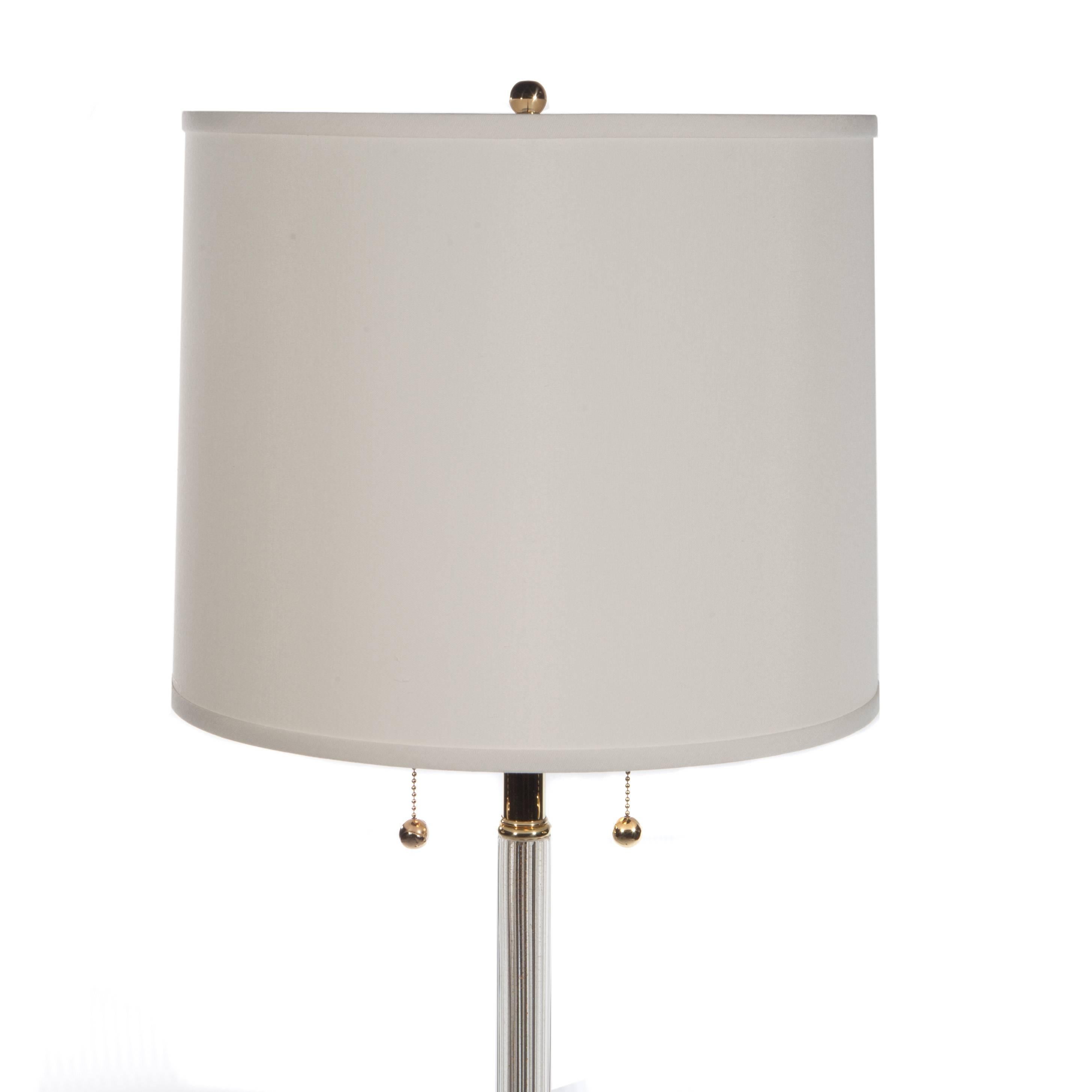 Elegant 1960s floor lamp with circular brass base supporting a single, fluted neck made of gold-flecked Murano glass. Completely rewired and restored with all brass elements re-plated and re-lacquered, new off-white linen shade. Two bulbs in