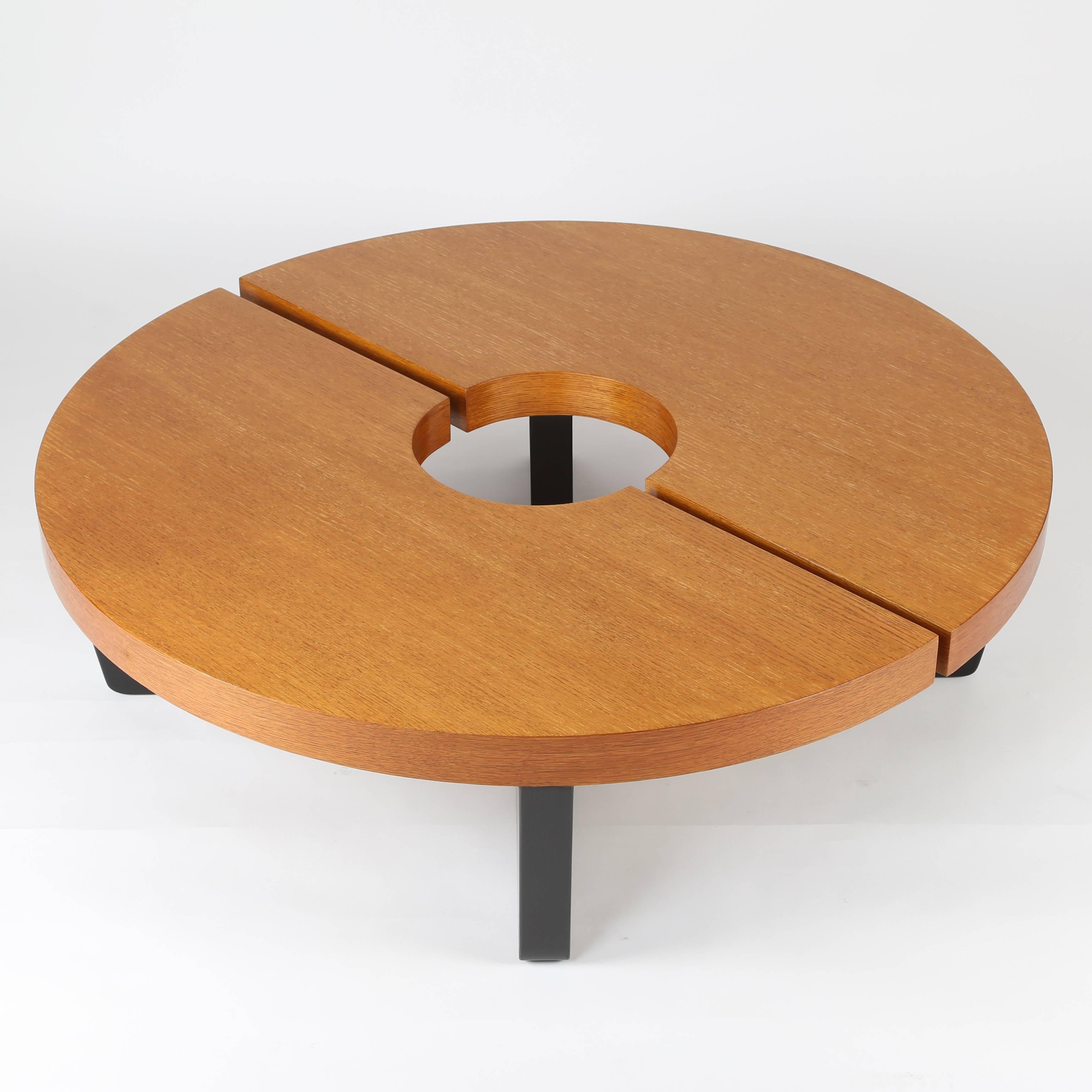 Iconic 1949 Harvey Probber cocktail table consists of two semi-circular sections that, when put together, form a complete circle with a 12" interior hole. The top of the table is a nicely grained oak in a natural finish; the slab feet are the