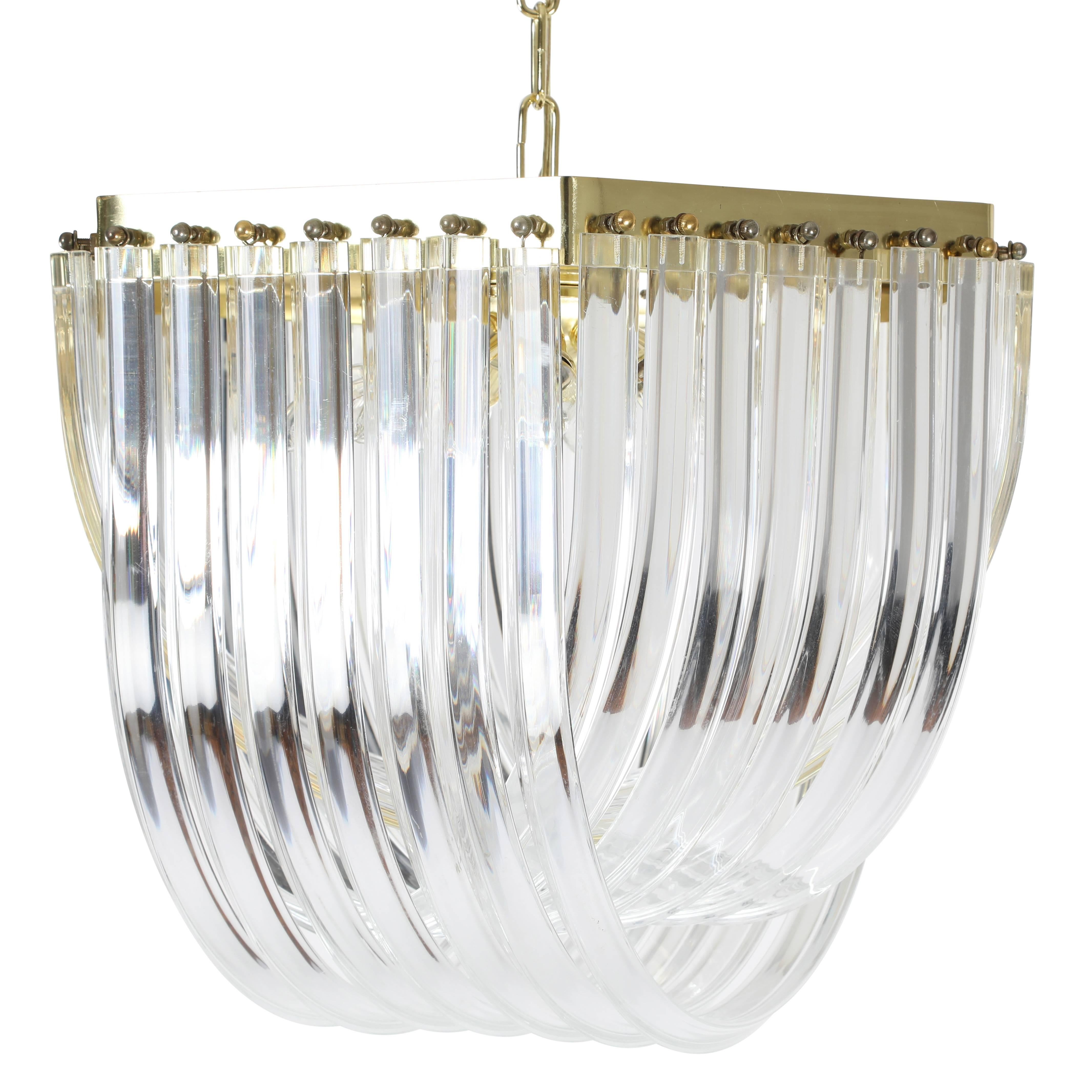 This vintage chandelier features 21 intersecting strands of bent and polished triangular Lucite, secured by brass hardware on a brass frame. Takes 10 40-watt candelabra bulbs. 

