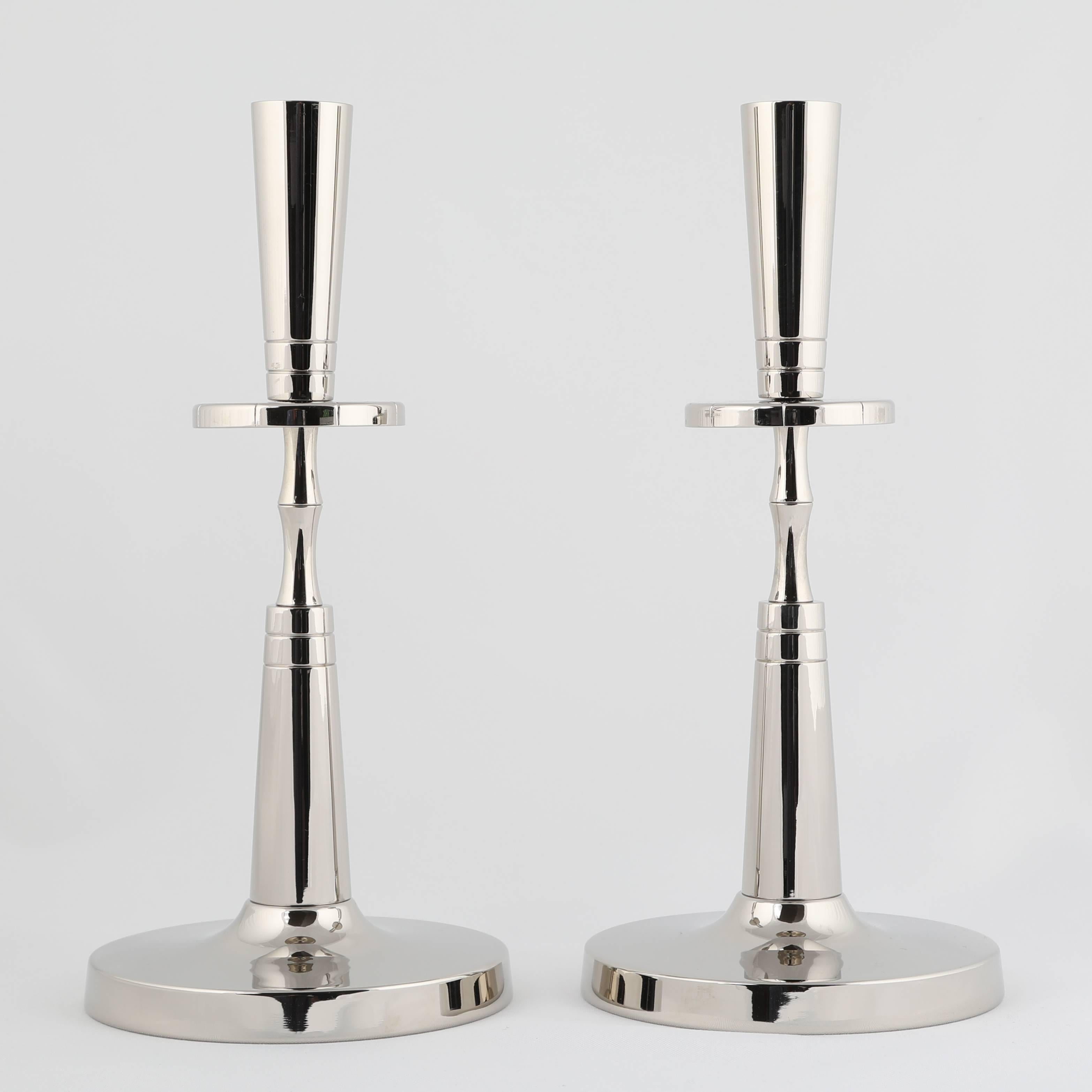 Pair of clean and Classic candleholders designed by Tommi Parzinger, circa 1950s. These were originally plated in silver, but we had them re-plated in polished nickel for easy maintenance. Stamped 