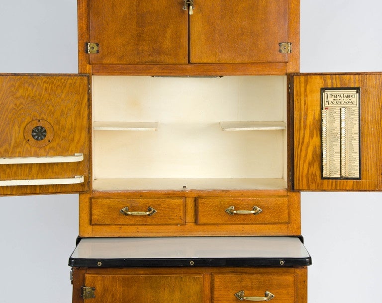 A rare surviving British Hygena housekeepers cupboard with its original fittings made from oak and ply with a pull-out enamelled metal work surface manufactured in circa 1927.