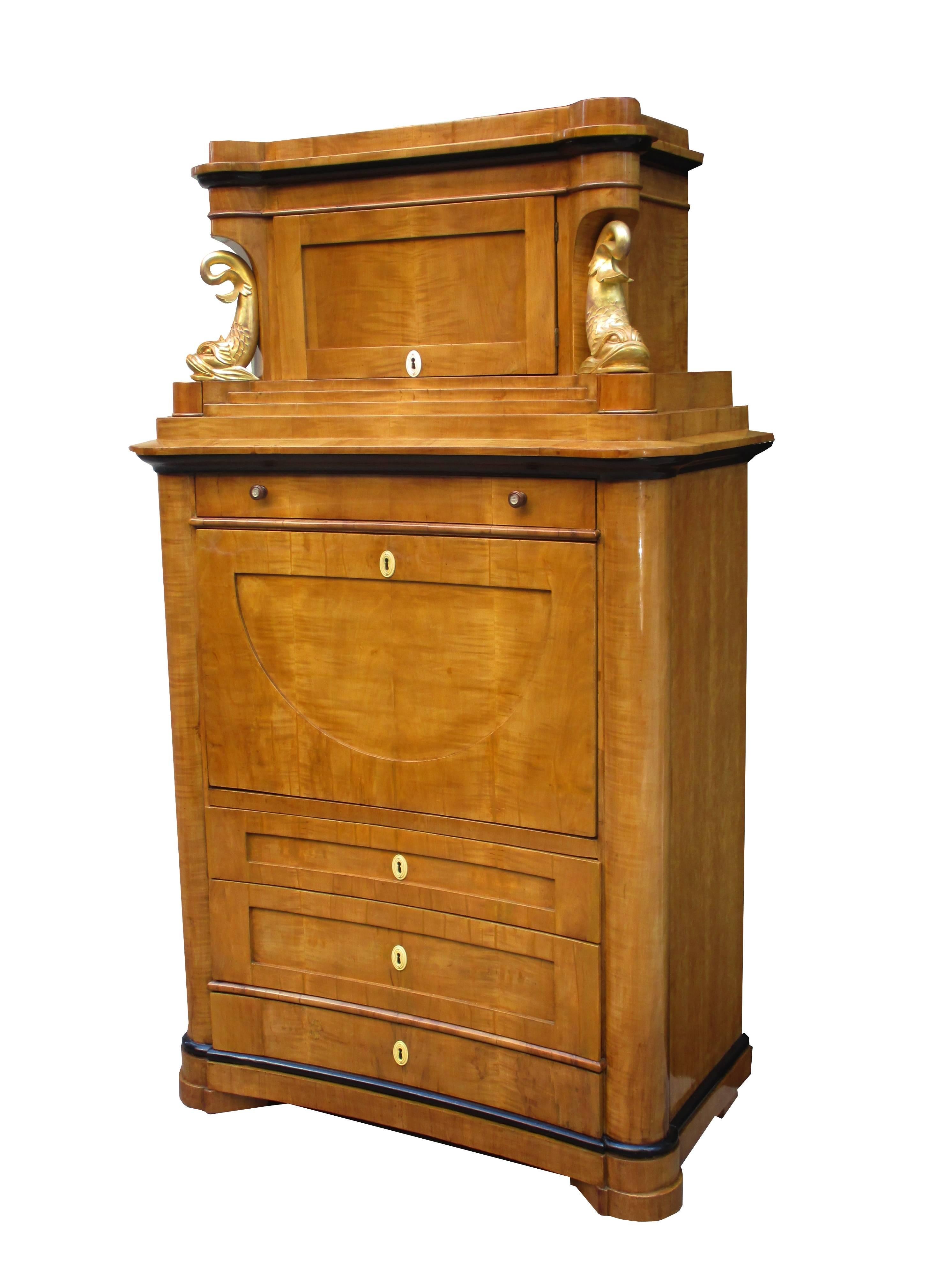 A fine Biedermeier secretary.
Cherrywood with ebonized fruitwood details,
carved giltwood details. Interior drawers in birch burl
with pull-out writing surface featuring a leather top.