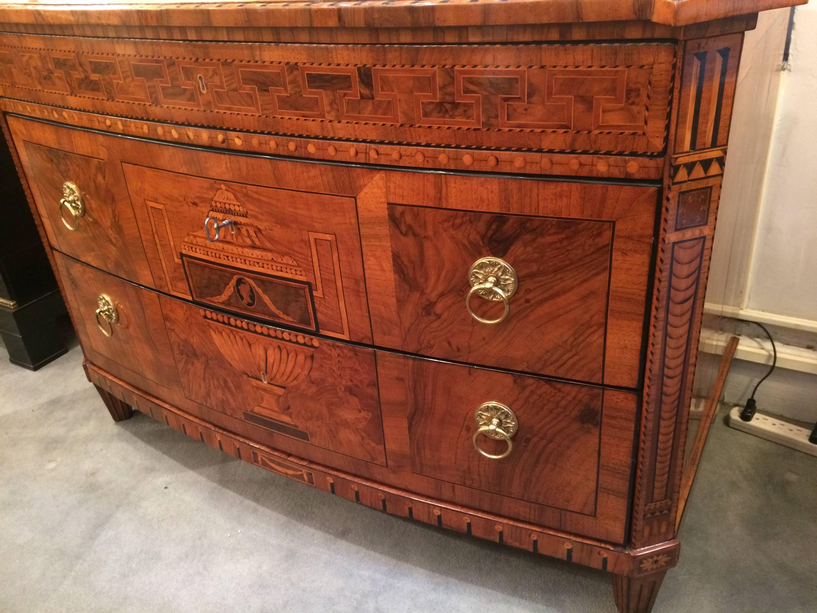 An important neoclassical chest of two drawers.
In walnut and walnut burl, with meticulous fruitwood and ebony inlay and marquetry details, patinated bronze pulls.
Dresden.