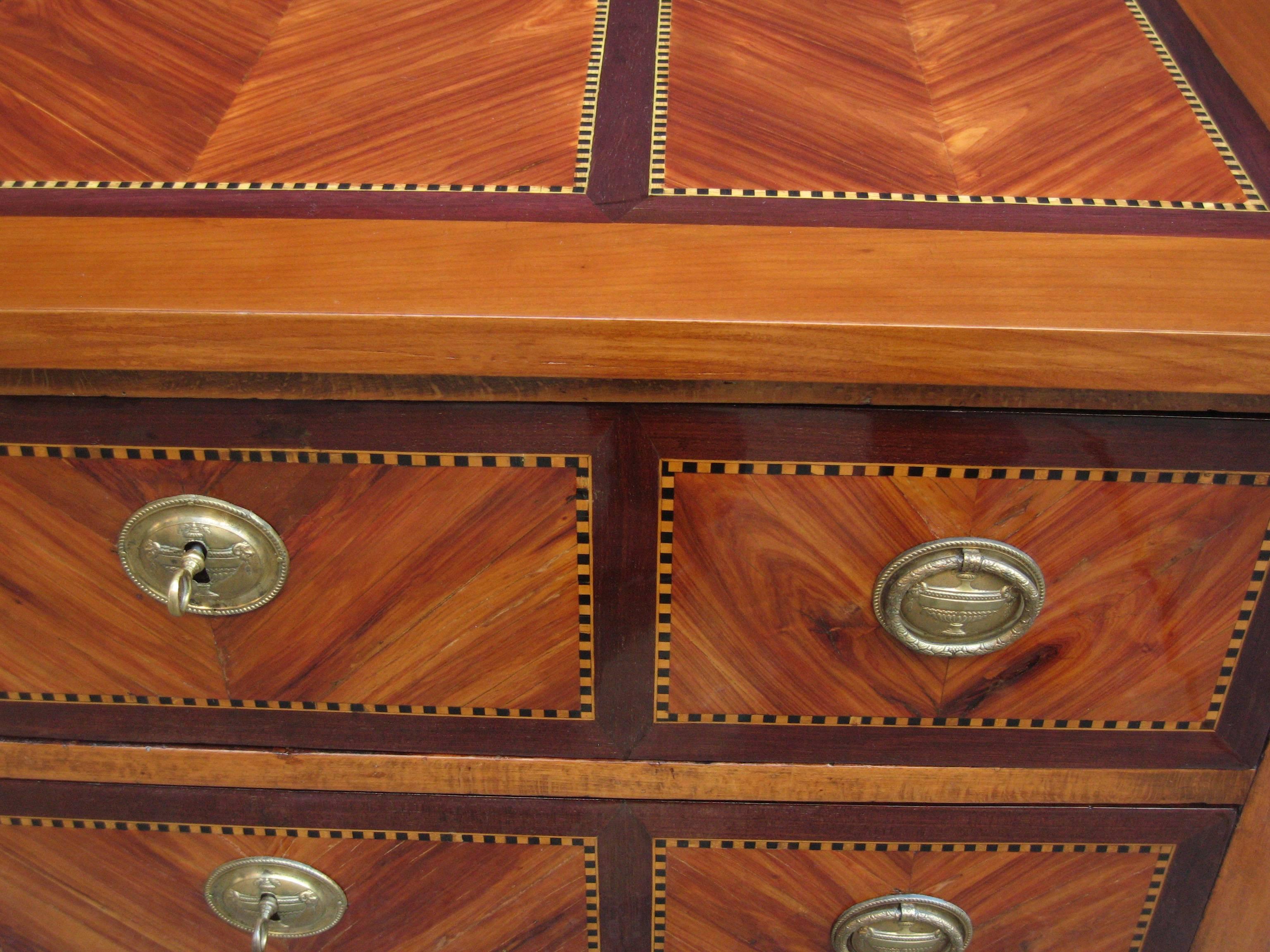 A fine neoclassical chest of drawers.
Mahogany with marquetry inlay and fruitwood inlay 
details with patinated bronze pulls and escutcheons.