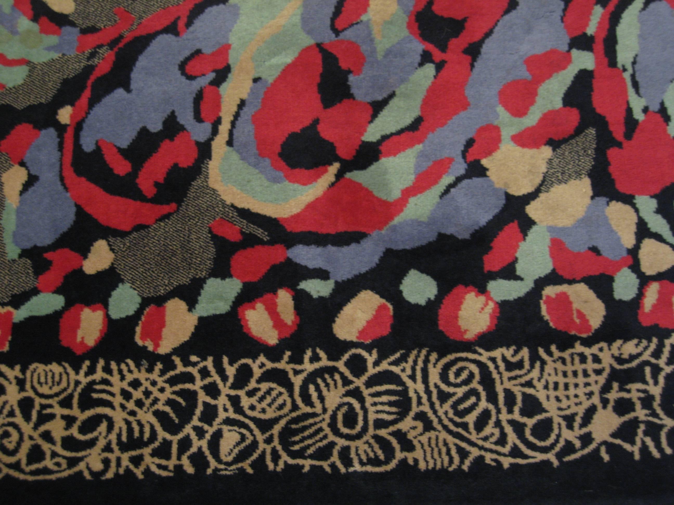 Un tapis de laine moderniste conçu par Pierre Balmain.
Composé d'un fond noir et d'une bordure décorative de couleur havane.
entourant la composition centrale du tapis dans des Hughes de couleur rouge, bleue, verte et beige.
Label d'origine :