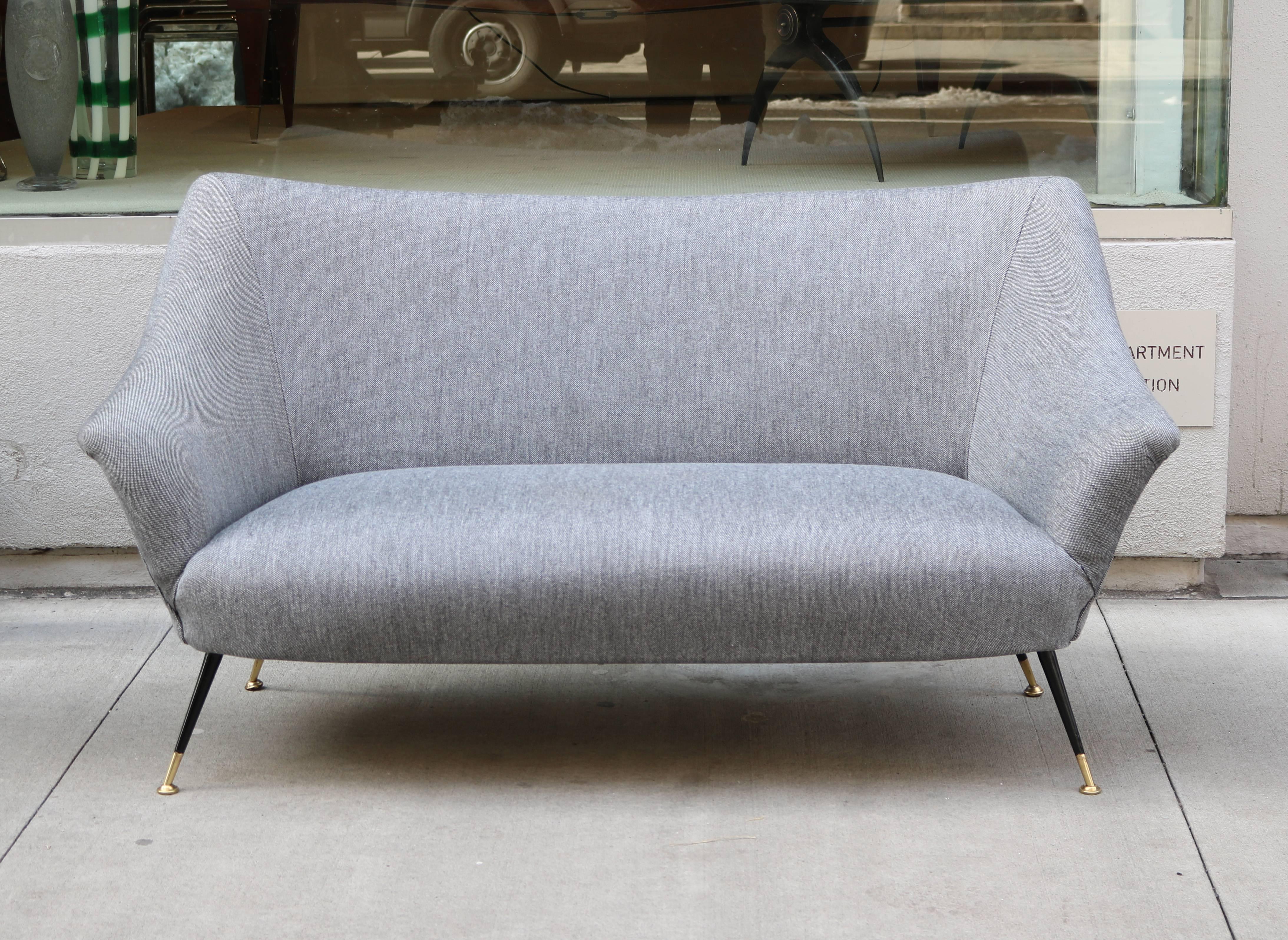 An Italian Modernist settee.
Upholstered with black enameled metal legs 
and patinated brass details.