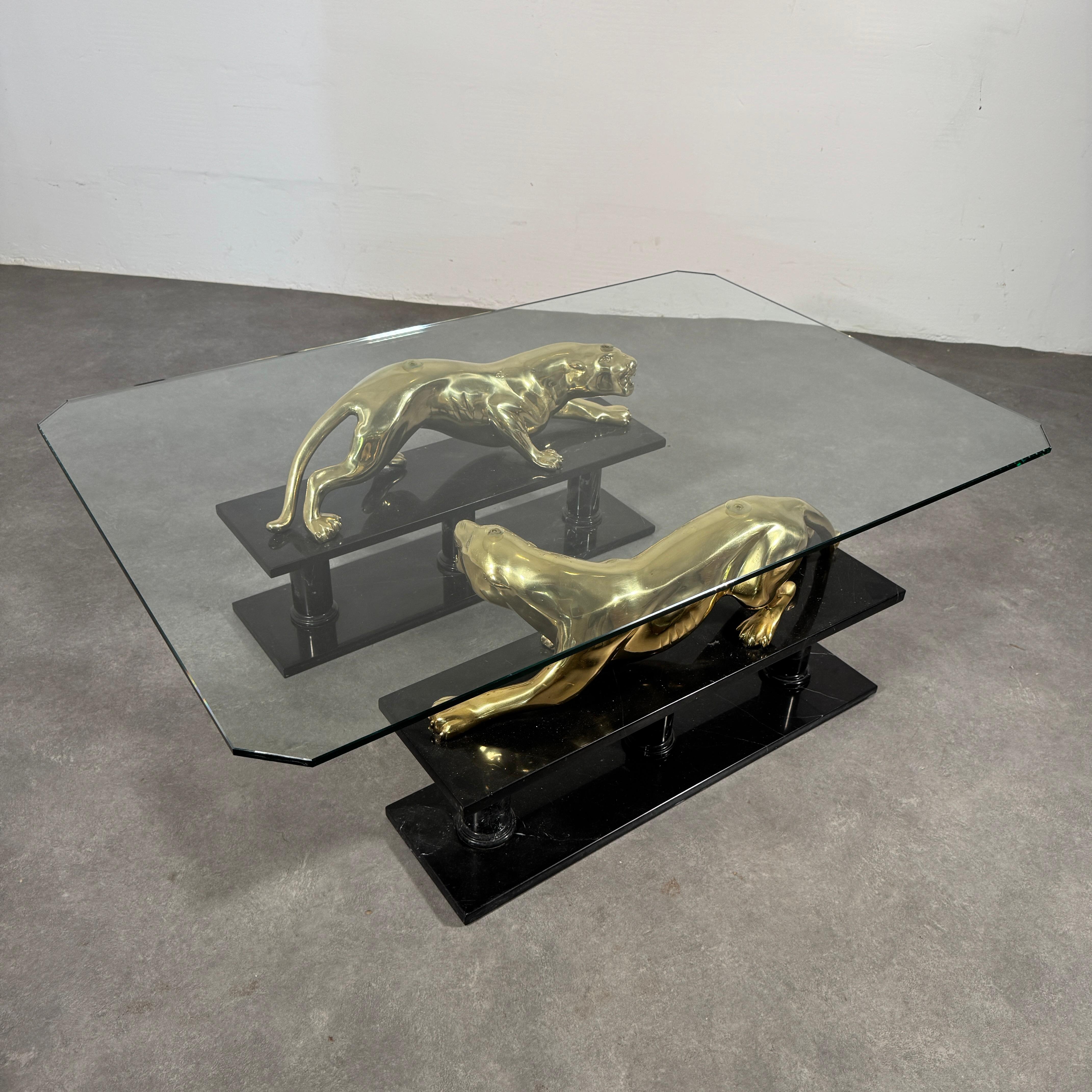 Mid-Century Hollywood Regency
Table basse de la Maison Jansen. 
Sculptures de léopards en bronze doré sur marbre italien noir.
France, années 1970.

qualité très élevée.

Les panthères peuvent être retirées de la base. Peut être utilisé comme