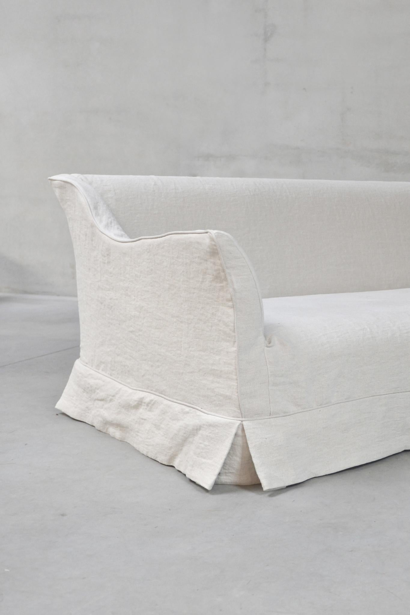 The Stephanie Sofa by am designs blends relaxed elegance with versatile functionality. Handmade in Belgium with a solid wooden frame, it features a durable construction and plush seat and you can add cushions for exceptional comfort. The fully