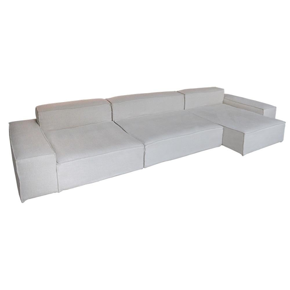 The Modular Sofa by AM Design offers a flexible, contemporary seating solution with timeless appeal. Handmade in Belgium, this sofa features a clean, low-profile silhouette and a relaxed slipcover, giving it a casual yet refined presence. Designed