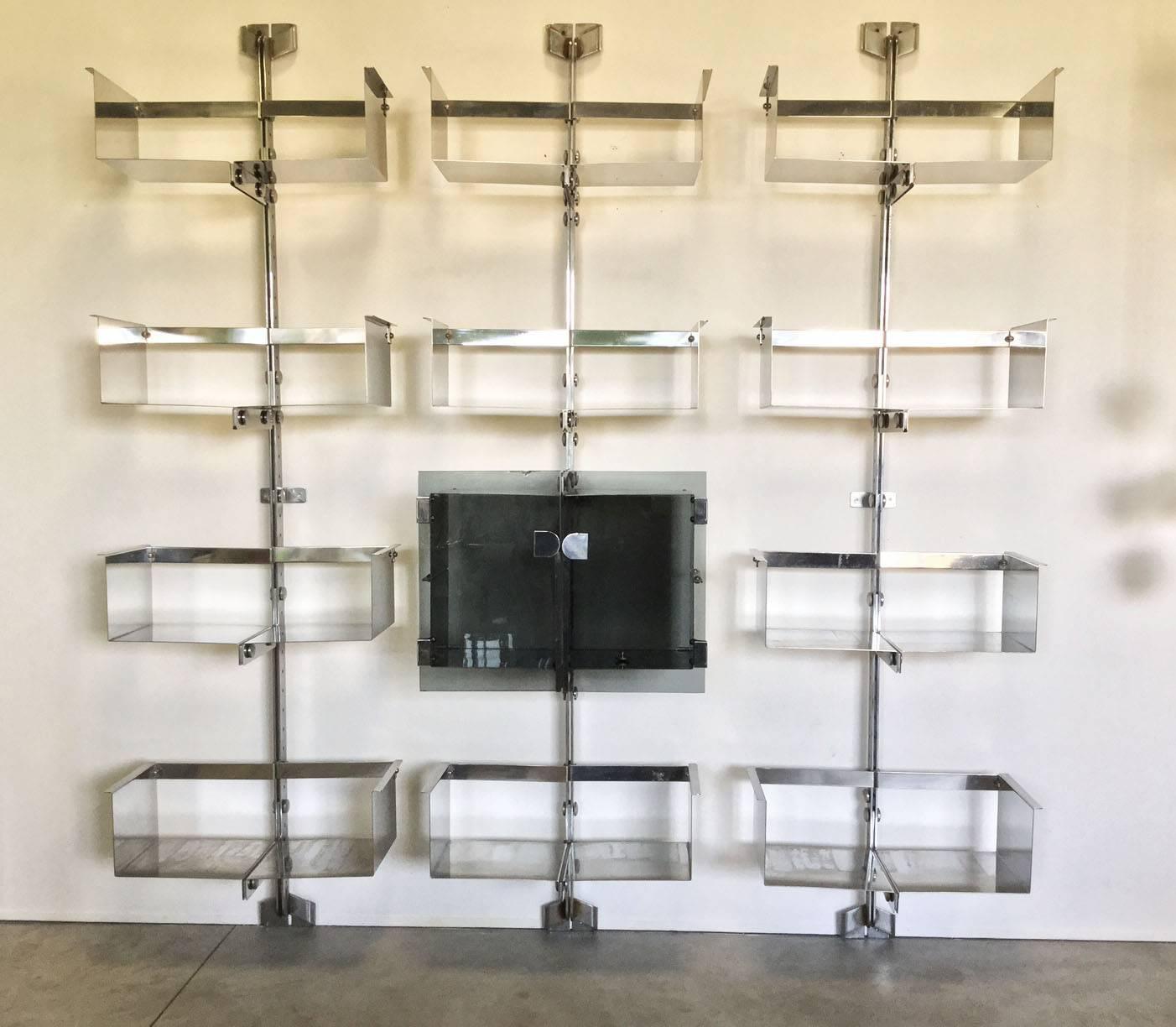 Beautiful three modules bookcase, steel chrome structure linked by large screws. 
Steel shelves with one two doors central window.
Original in all parts.
Designed by Vittorio Introini prod. Saporiti in 1970.