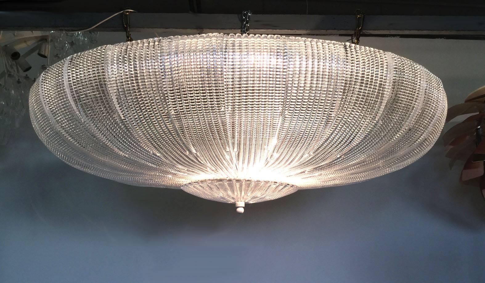 Beautiful chandelier made with glass slotted bands closed by a final disc, the total shape is that of a sea urchin, the look is impressive and spectacular 
Frame in white lacquered iron. 
Made by Barovier in 2010 with inspiration to 1940 models.