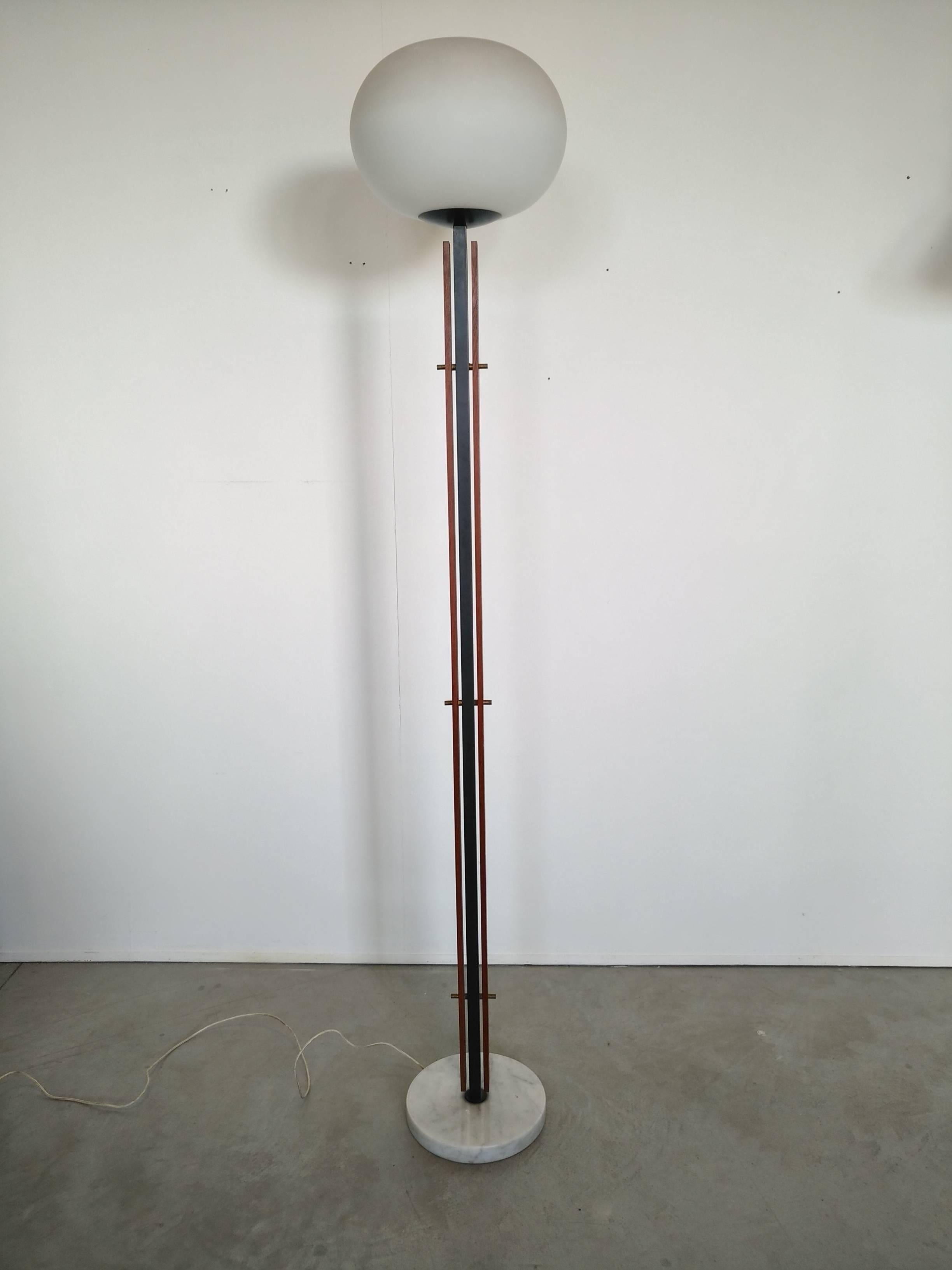 Beautiful and rare floor lamp with circular marble base , iron stem with sides wood bands linked by custom brass screws, the stem is surmounted by a opaline glass ball as diffuser
High quality of materials and construction this lamp can be compared