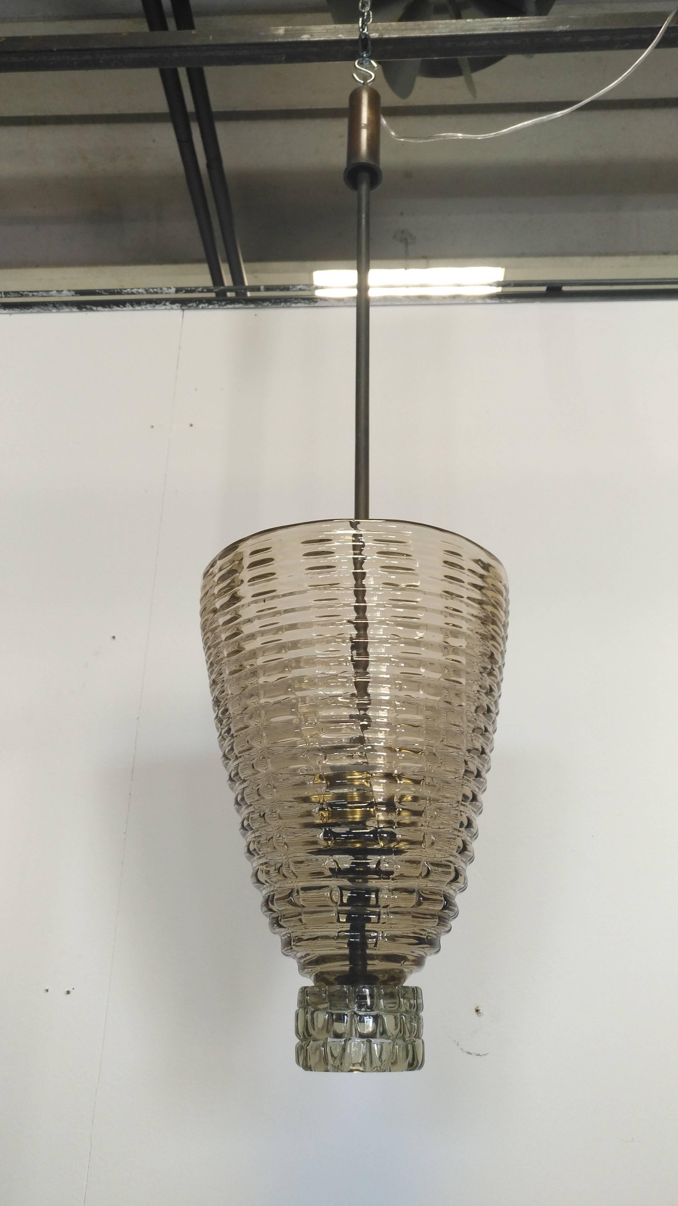 Beautiful chandelier with brass stem and a large cup iridescent amber glass as diffuser, final glass with brass custom screw with engraved Venini signature
Original in all parts from 1940, designed by Carlo Scarpa and manufactured by Venini
The