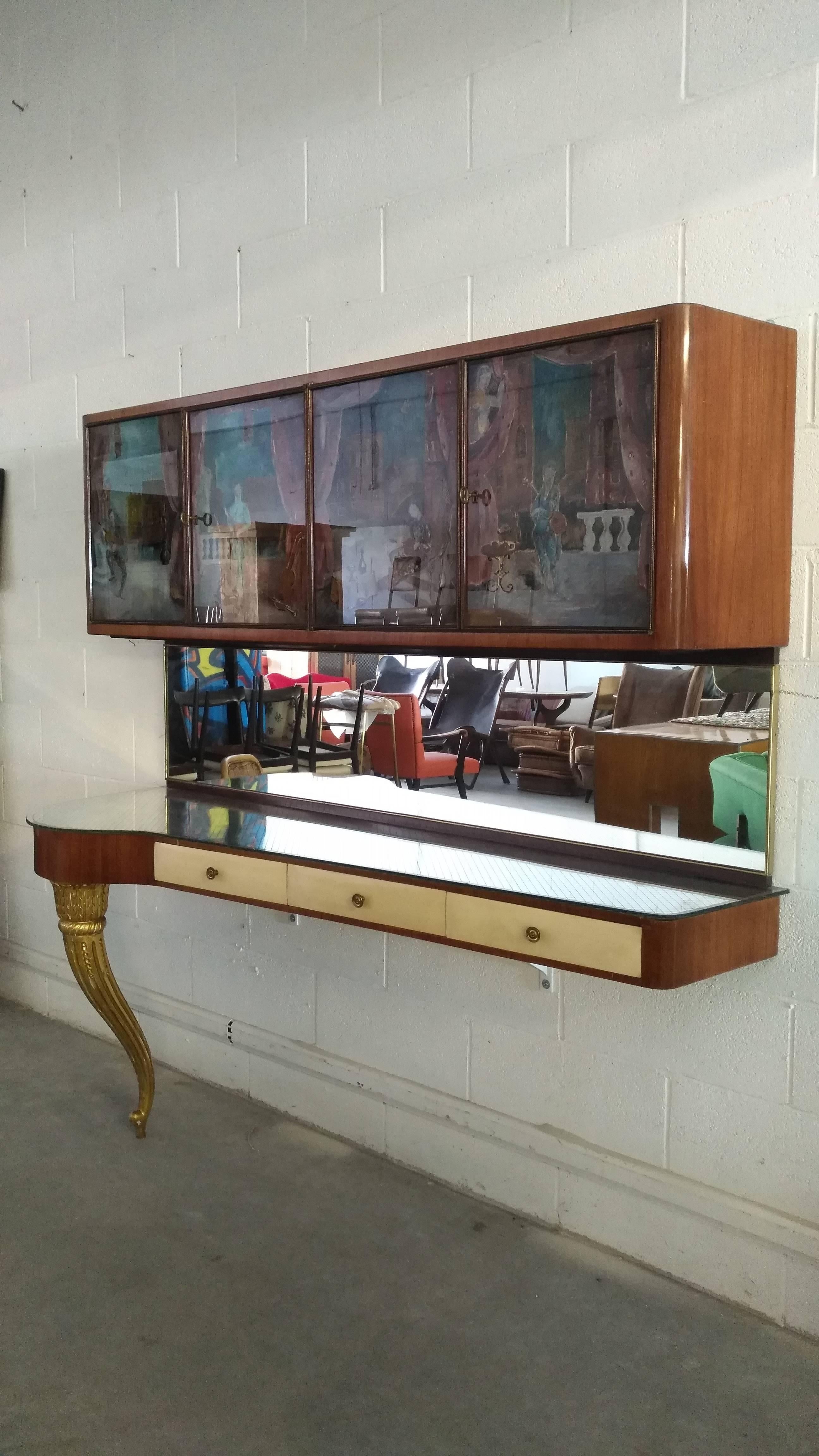 Beautiful hanging console with gilded carved wooden leg, three central parchment drawers surmounted by a engraved glass top and wall mirror, hanging furniture with four painted glass doors with venetian scenes
Mahogany wooden structure with maple