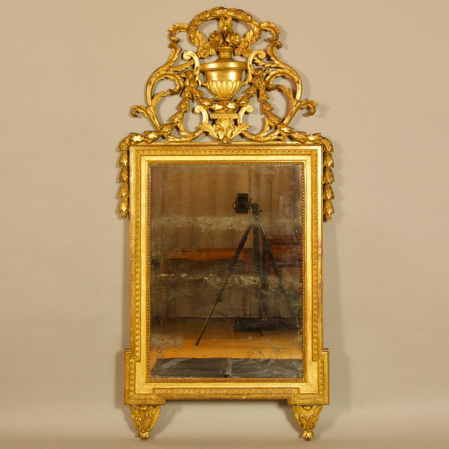 French 18th Century Louis XVI Neoclassical Giltwood Vase Motif Wall Mirror

The giltwood mirror containing the original mercury mirror plate within a moulded and beaded frame without-set corners. The large, pierced cresting elaborately carved with a