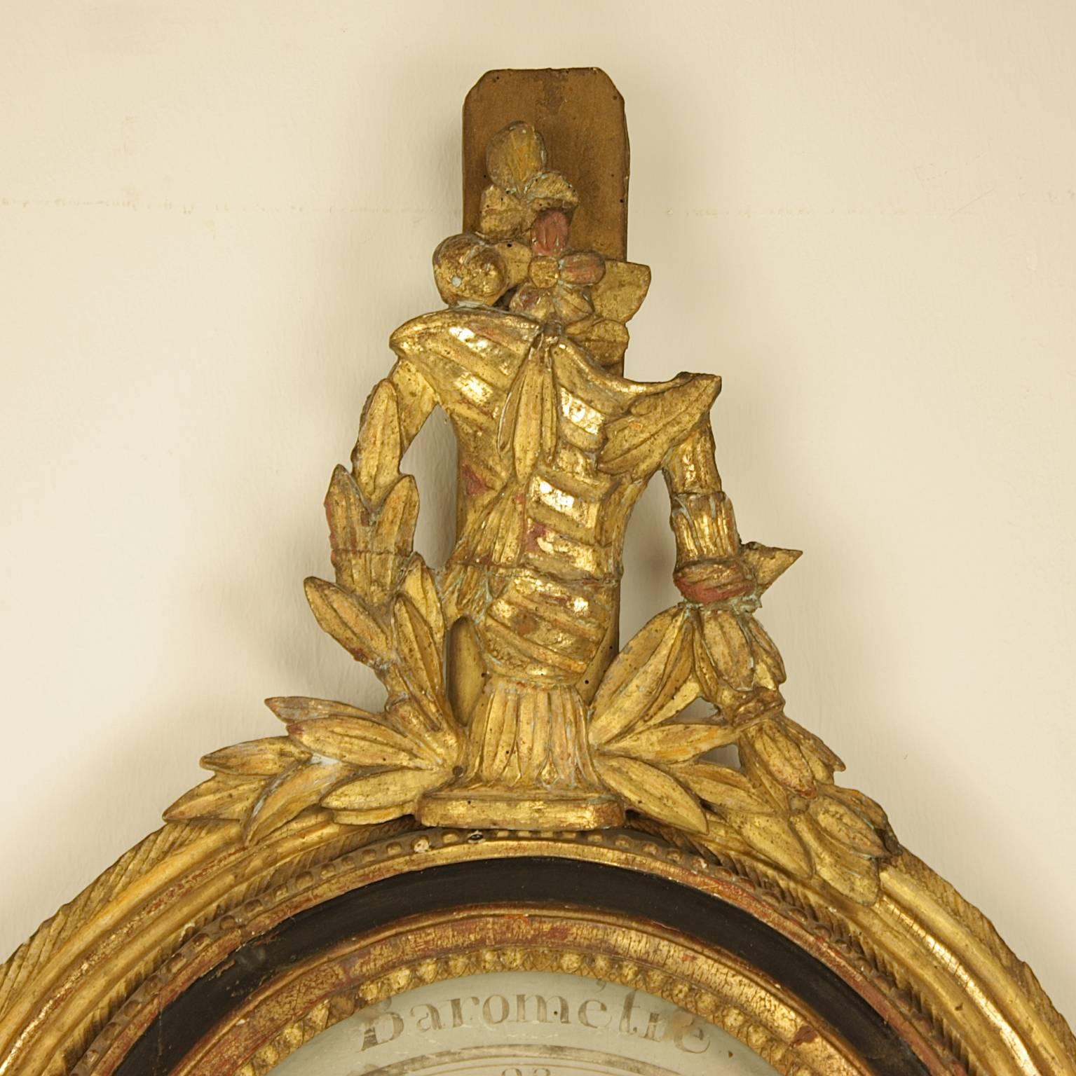 An 18th century Louis XVI black painted and giltwood barometer, the painted oval dial inscribed Barometre, signed and dated Mantelly & Rossy 1753, within a molded framed with a beaded border, flanked by a beautifully carved ribbon bound moulding,