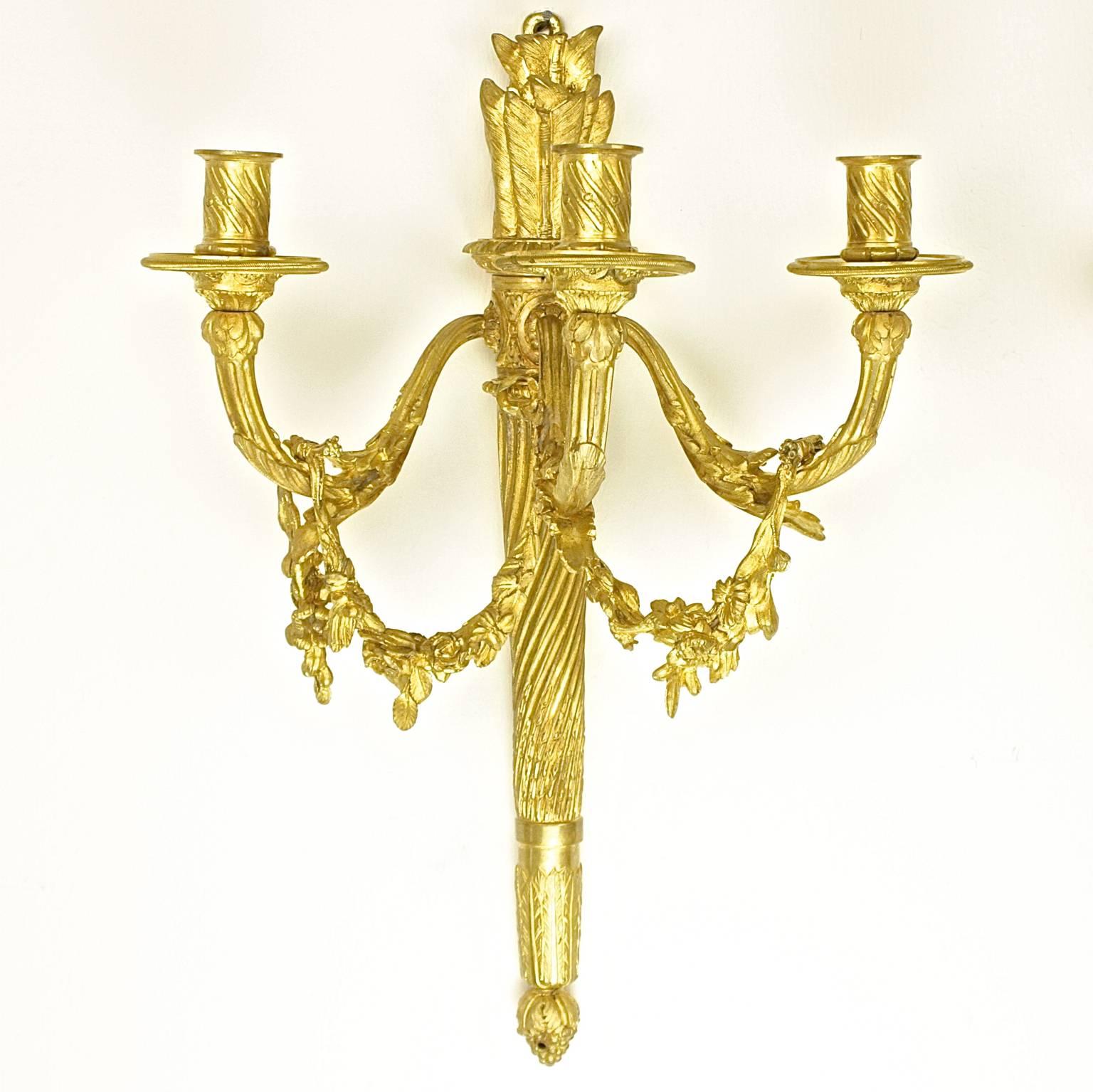 Paar dreiflammige vergoldete Bronzewandleuchter im Louis-XVI-Stil, H. Vian zugeschrieben

Ein Paar dreiflammige Wandleuchten im Louis-XVI-Stil in Köcherform, die jeweils drei Arme von einer fein ziselierten Rückwand aus haben, die eine verdrehte