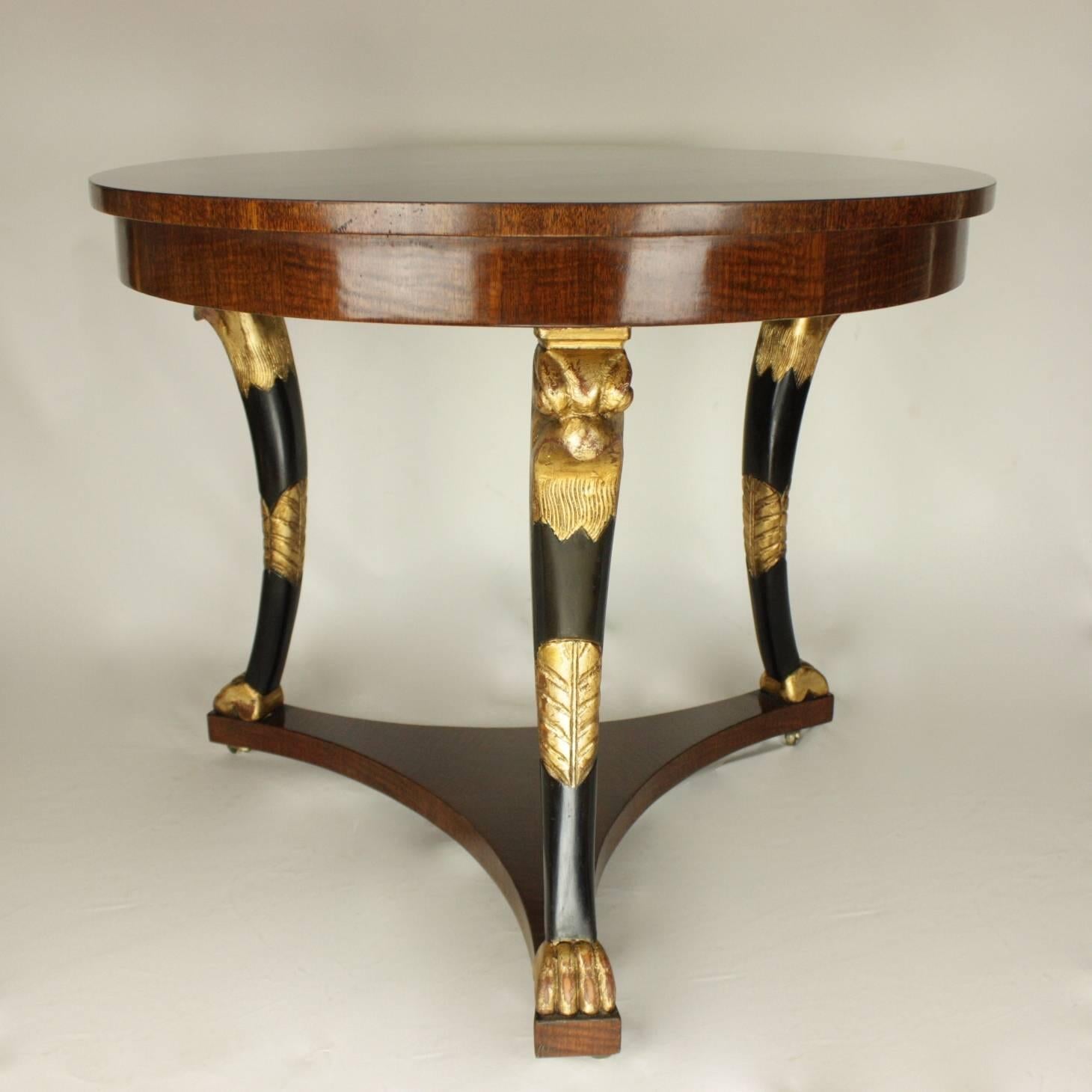 Late 19th century Empire style centre table with an eye-catching mahogany veneered tabletop and horus headed giltwood and ebonized legs. Horus is one of the most significant ancient Egyptian deities - he was the divine representation of the living