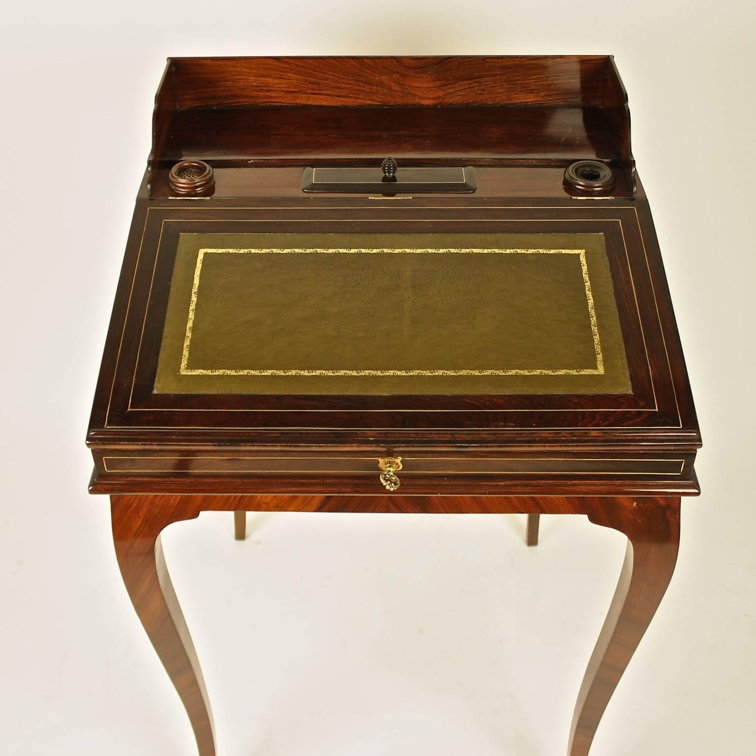 A small 19th century mahogony bonheur de jour or ladie's desk with a rectangular hinged top fitted with a green leather lined writing surface, opening to reveal two drawers, raised on cabriole legs.

This desk is of a type known as a