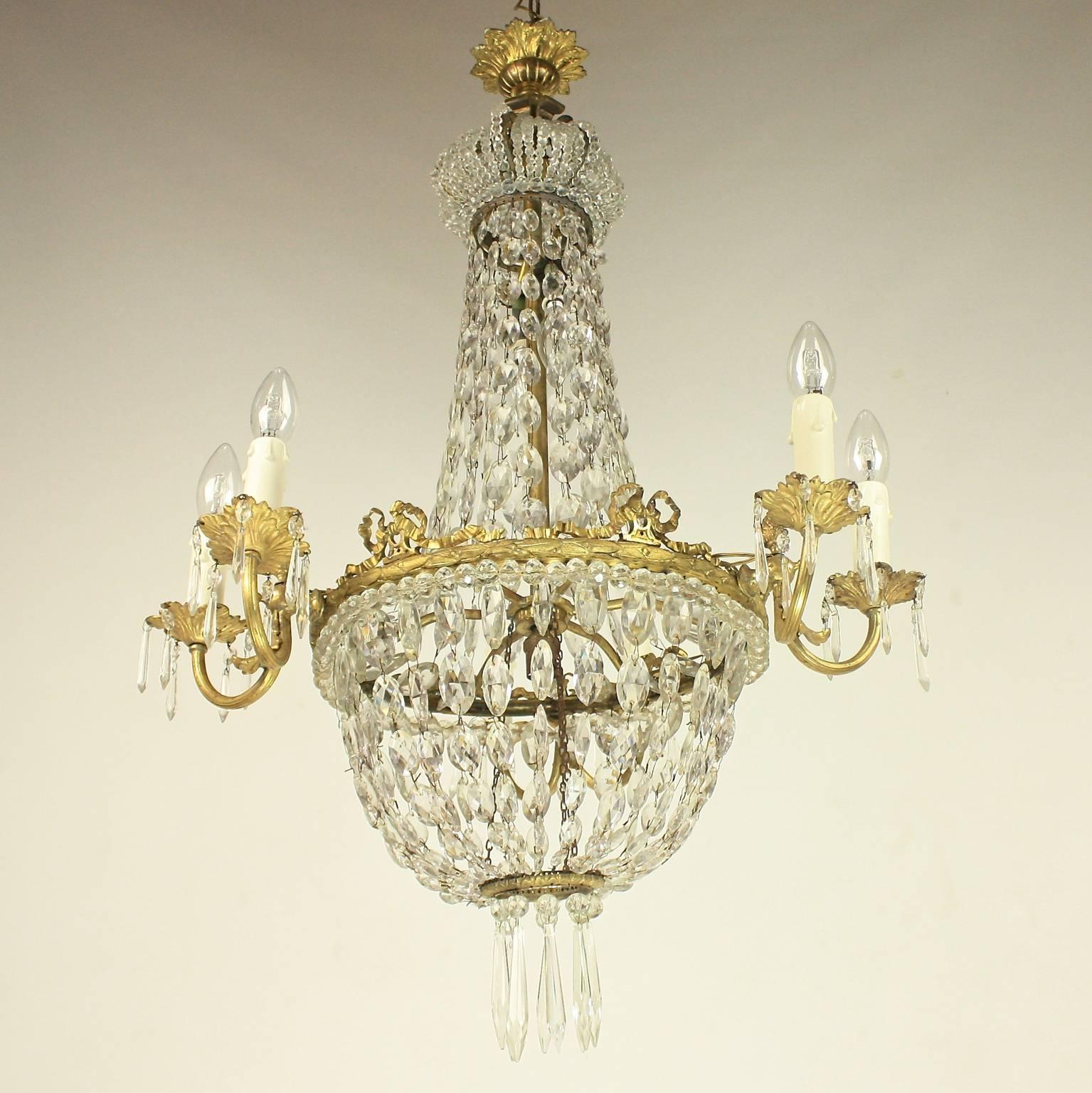 A late 19th century French gilt bronze and cut-crystal basket chandelier with a corona in the form of a crown made of small facetted pearls, hang with chains of crystal drops with a central ring cast and finely chiseled with a laurel and berry