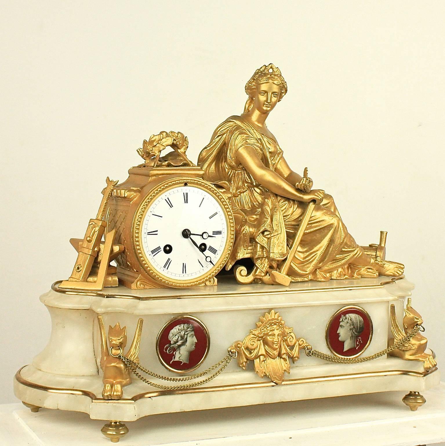 A French 19th century alabaster mantel clock, the white enamel dial with Roman numerals within a bronzed metal case, flanked by a female figure wearing the laurel leaf crown of victor and holding a Hammer, the whole being an allegory of manufacture
