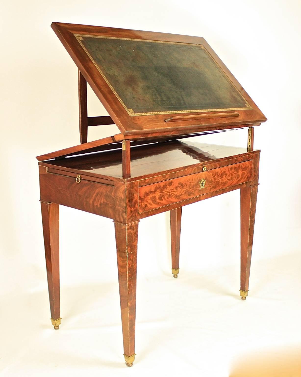 A late 18th century Directoire mahogany architect's table, attributed to the workshop of  Jean-Joseph Chapuis. 

A mechanical table with a double-hinged ratcheted top and a gilt-tooled green leather lined writing surface, veneered in beautifully