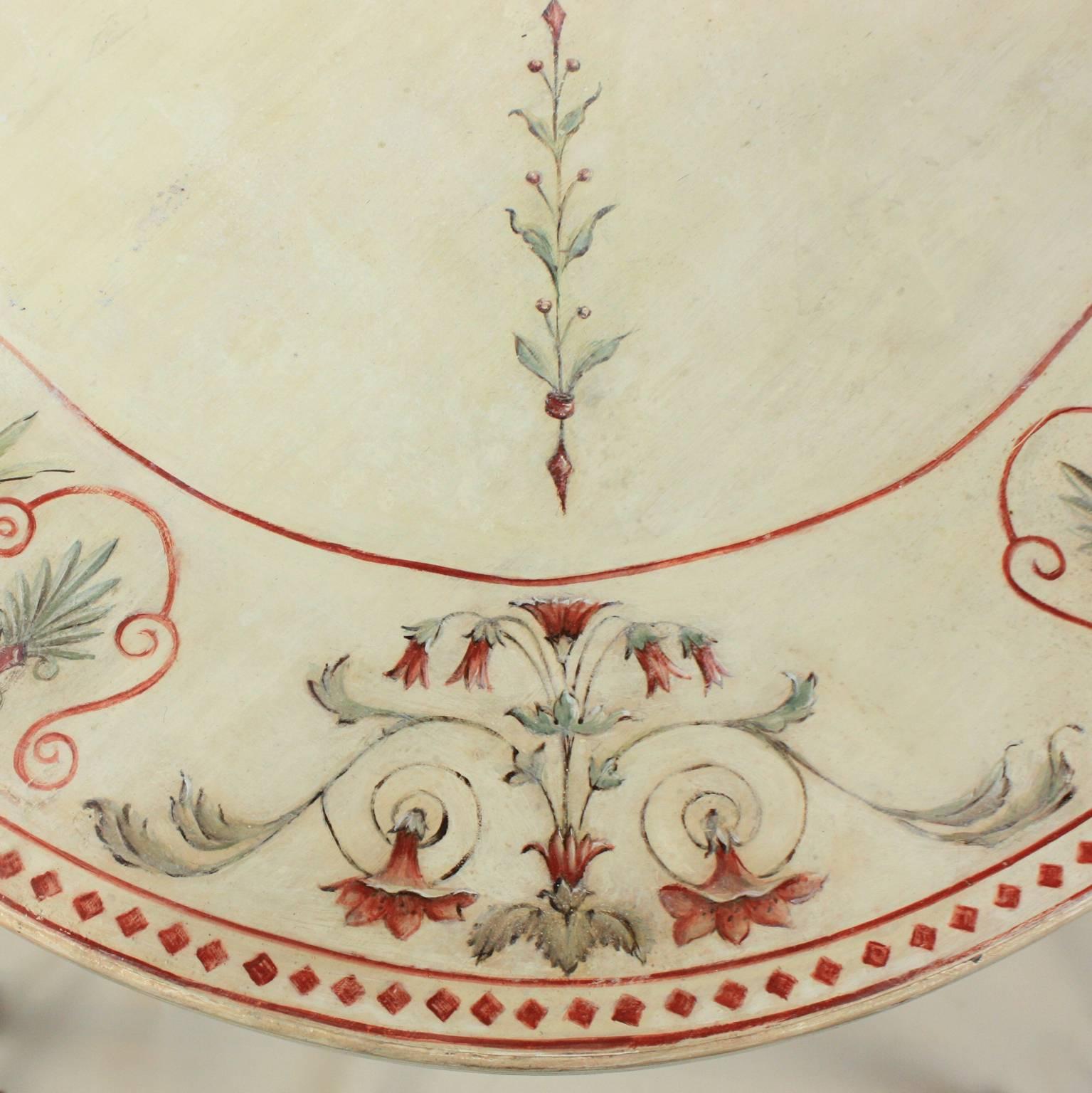 A 19th century English white, red and green/ blue painted breakfast table, with a central fan motiv, a diagonal foliate and flower interlinkage to the border decoration comprising of four different flower motifs on each corner and a Greek cyma link
