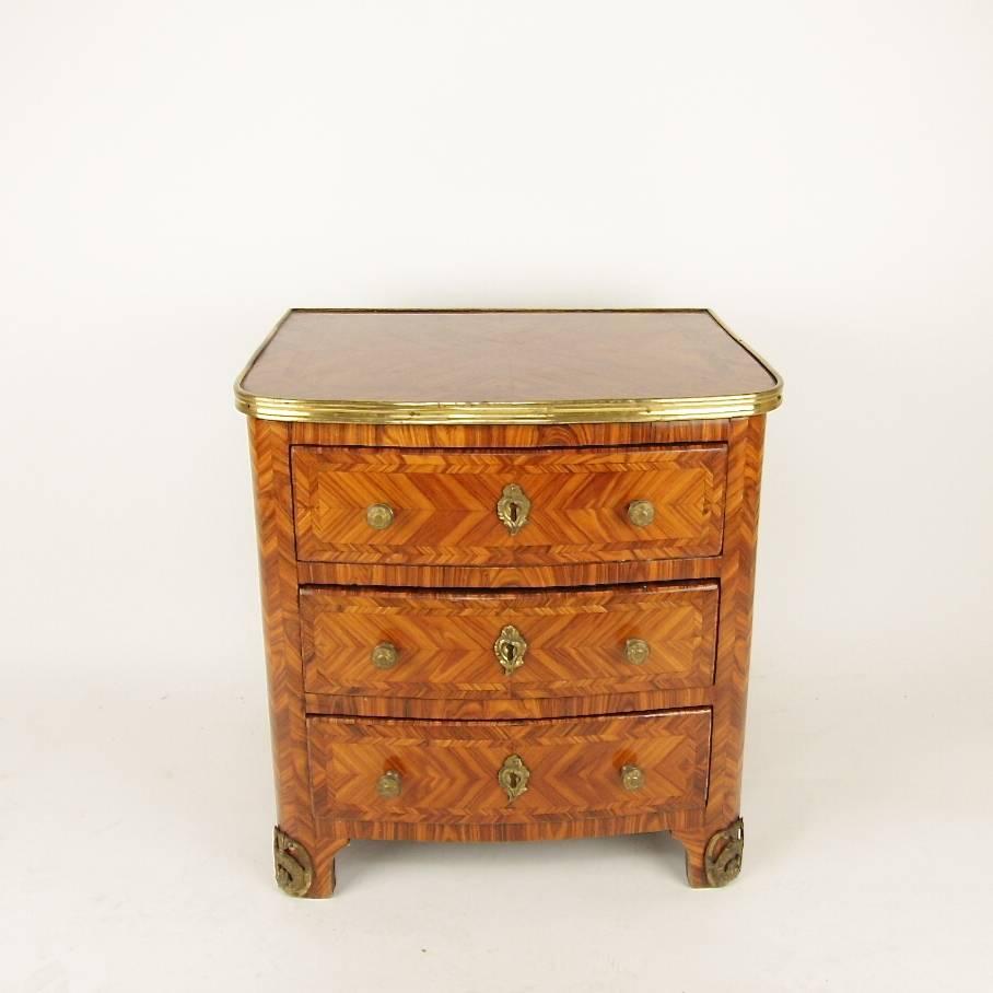 A late 19th century children's commode veneered in tulipwood with a brass banded brass surround, rounded corners and gilt bronze mounts on bracket feet. Its height and size must be the delight of any toddler and small child. With three drawers