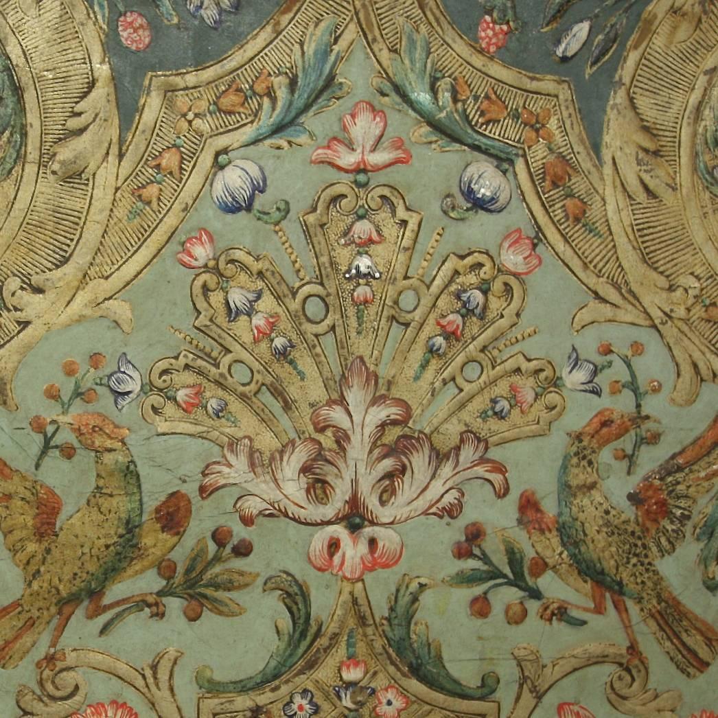 A Baroque embossed and polychrome painted leather three-leaf screen after a design by French furniture designer, architect and engraver Daniel Marot (1661-1752). Each leaf comprising two identical rectangular panels, each with a central, shaped
