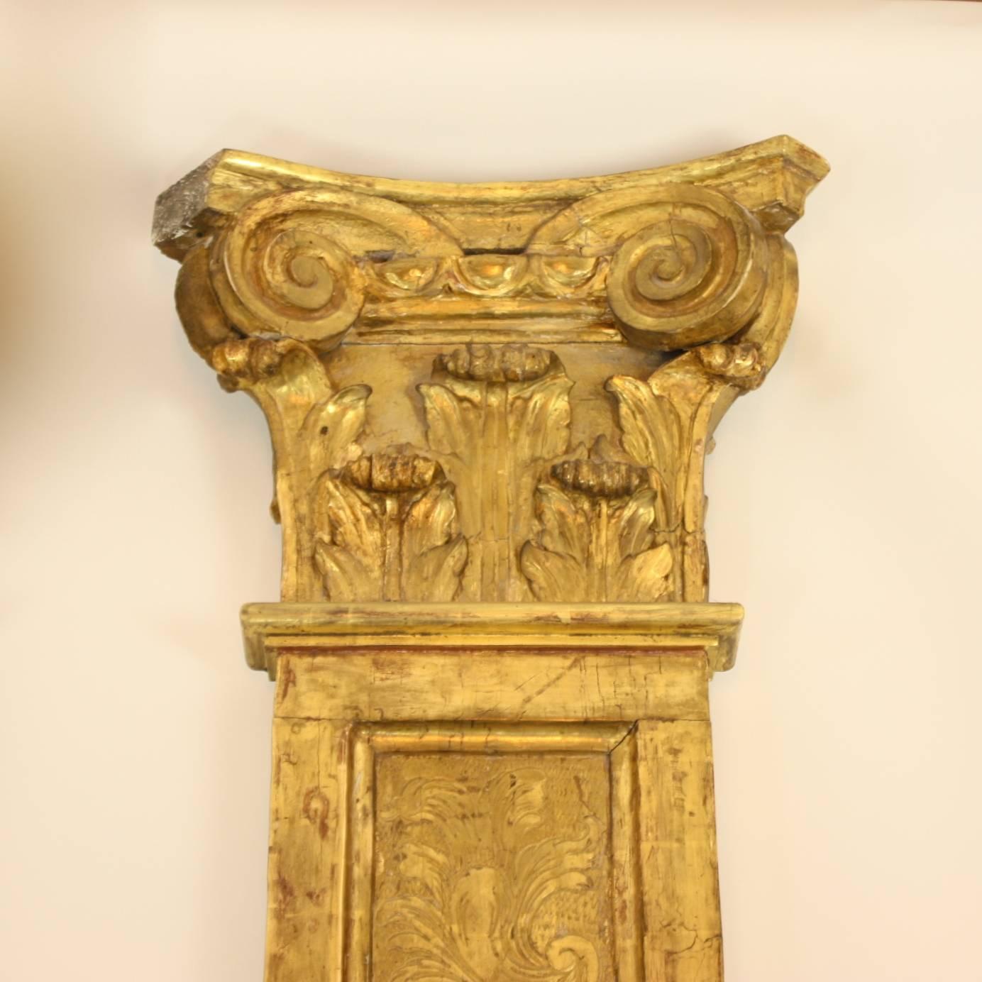 Pair of Régence carved and giltwood pilaster, comprising a composite capital as it was known from Roman times. The corners are finished with scrolling volutes, the abacus carries egg and dart ornament above acanthus leaves, their tops curling