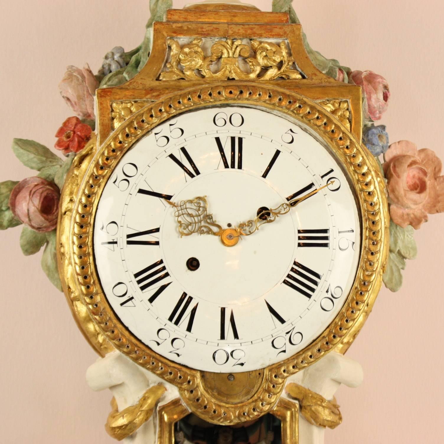 A large late 18th century Prussian carved wood, painted and parcel-gilt sonnerie bracket clock with wall bracket. The dished white enamel dial with Roman and Arabic numerals and pierced gilt hands, the barrel movement with verge escapement, striking