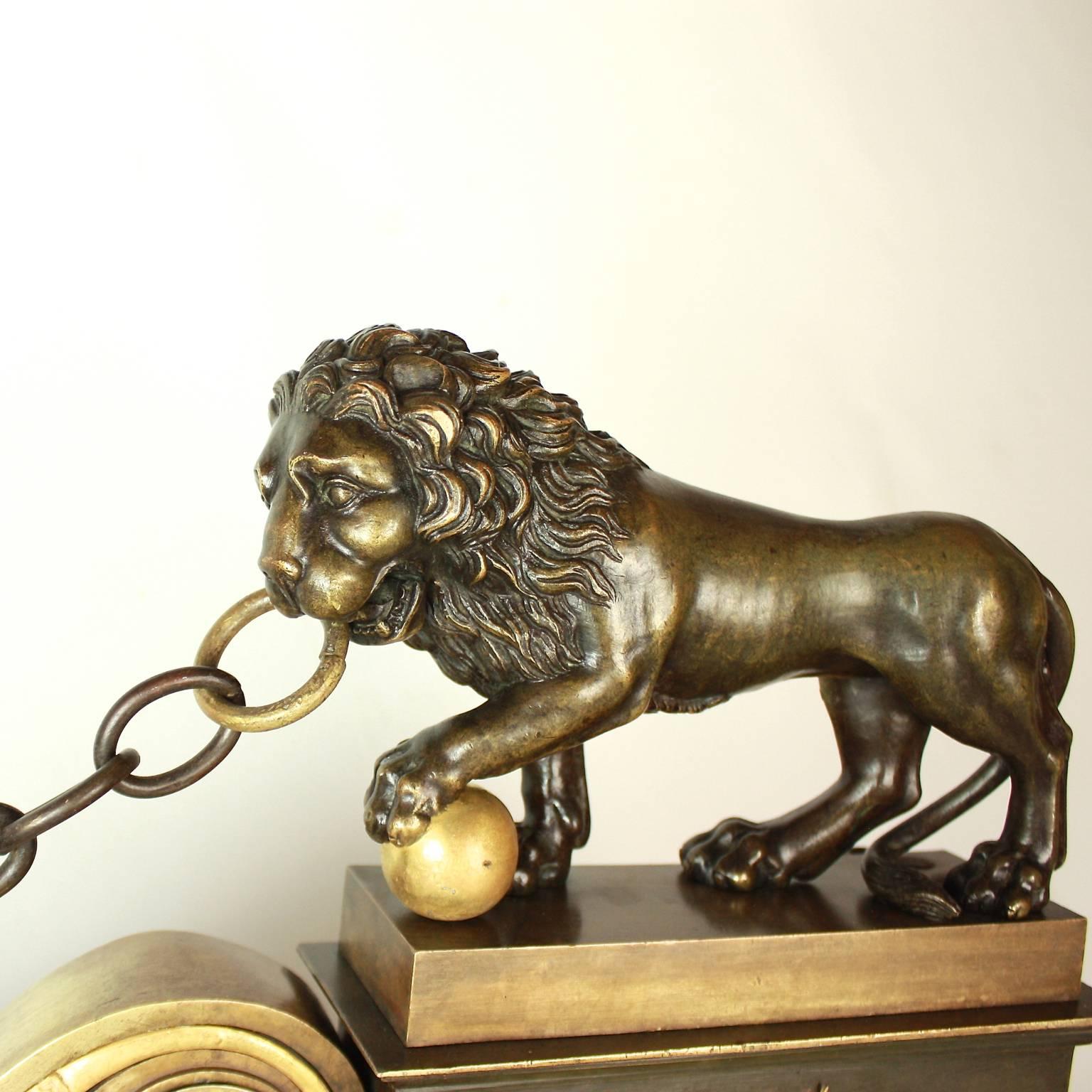 An Empire ormolu and patinated bronze fire fender from the early 19th century, of angular shape depicting the 'Medici Lions' over a stepped plinth. Both Lions are holding on to a chain with a ball under one paw, looking to the side. The mounts