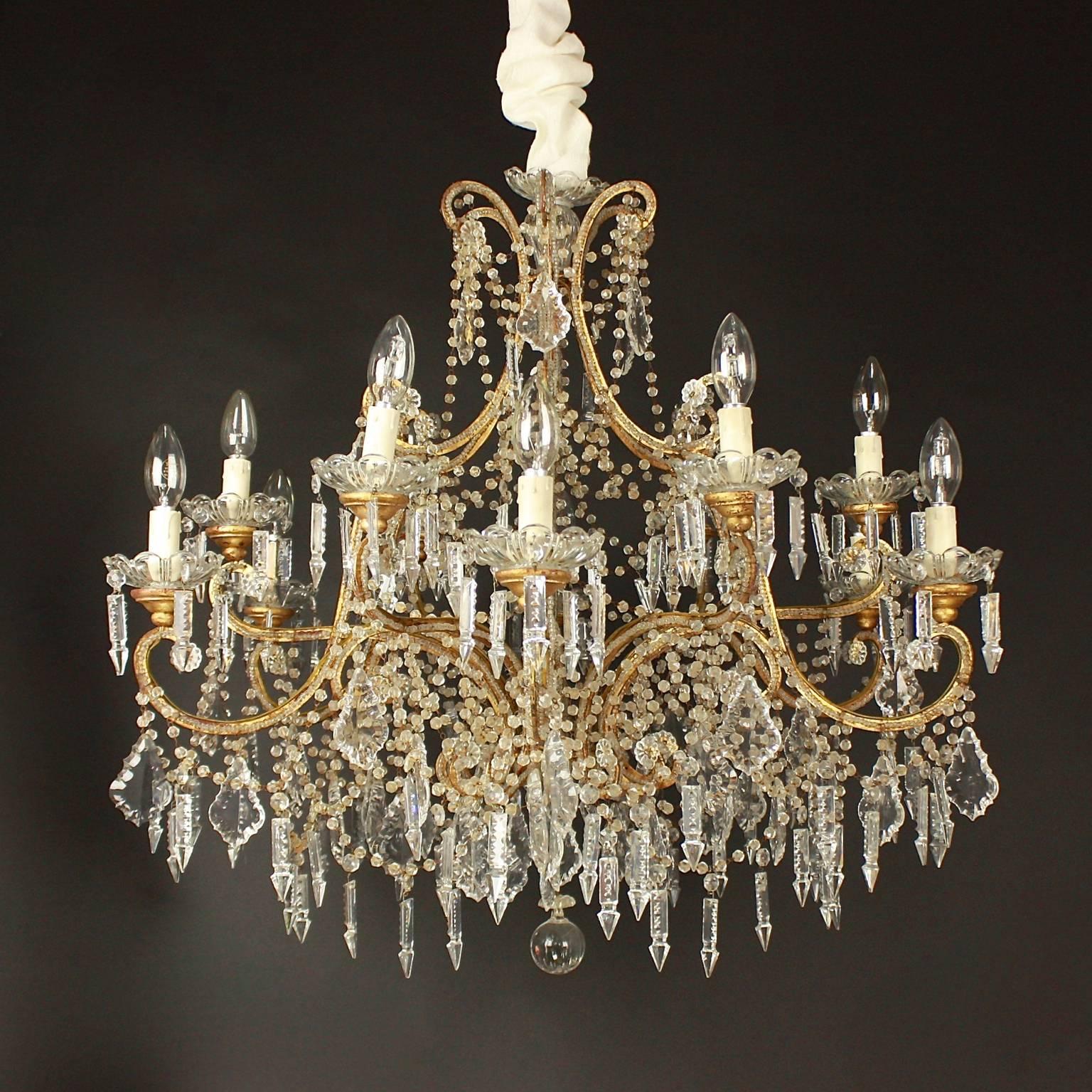 A Italian crystal cut twelve-light chandelier from the region of Nice in the South of France. With two tiers, each issuing six gilt-bronze beaded arms with fine bobeches hang with icicle crystals. The arme adorned with pendeloques and icicle