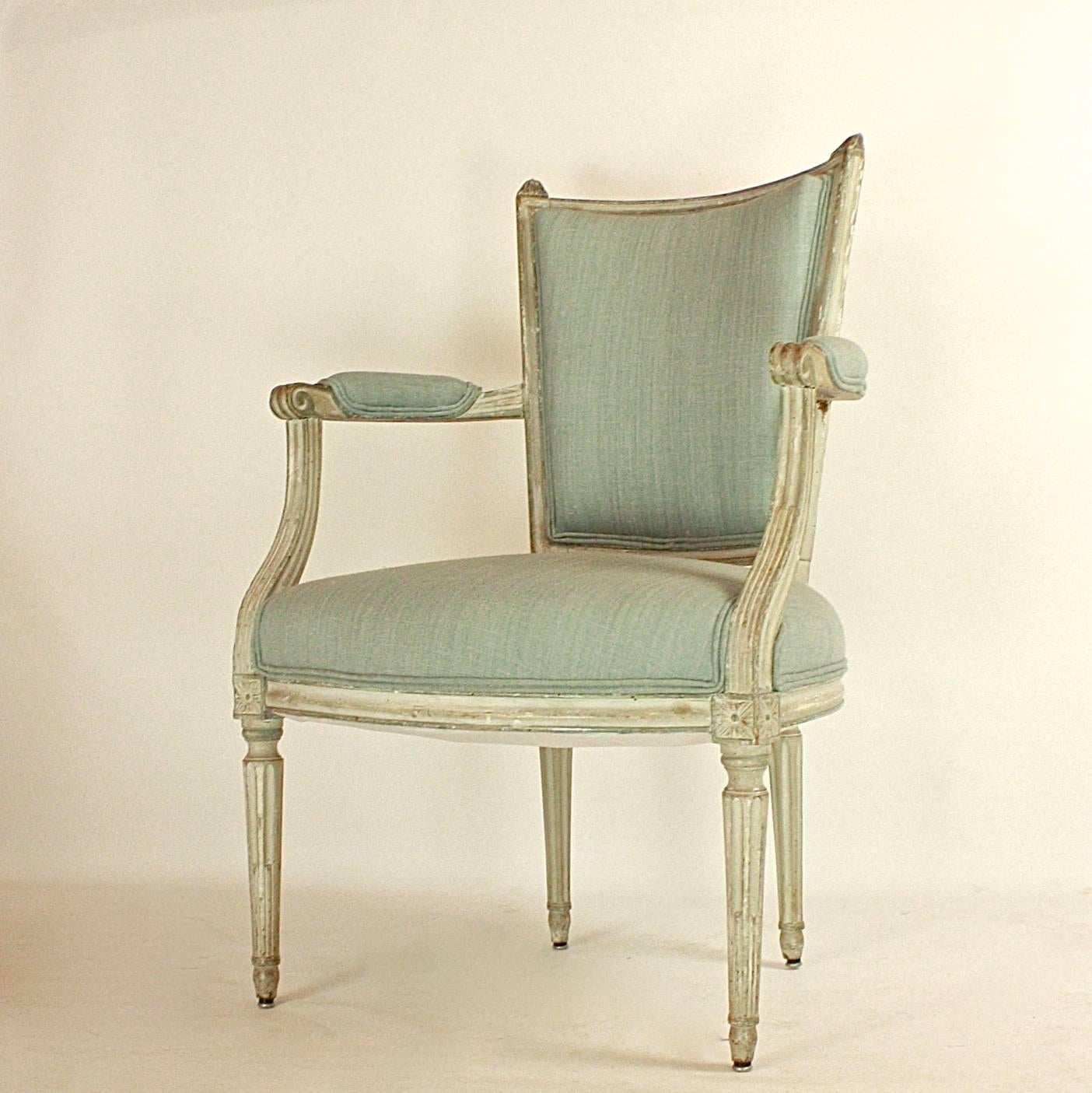 Pair of Louis XVI armchairs or fauteuils 'en cabriolet' in the manner of J.B.C. Sene.
The curved backrest with a straight top rail and pointed finials, the padded recessed armrests above four turned, tapering, fluted legs ending in toupee feet.