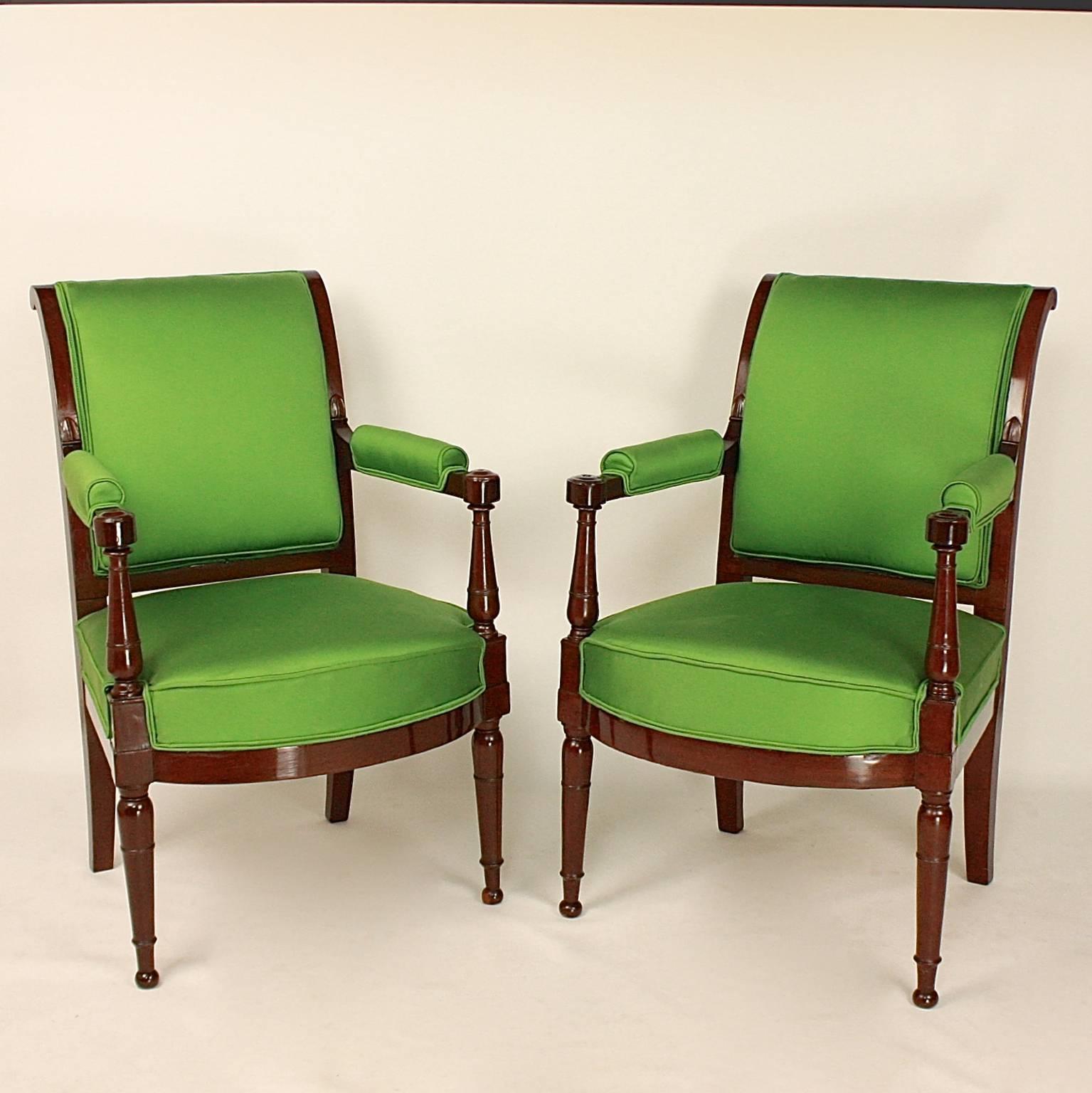 A set of four Mahogany armchairs or Fauteuils, in the manner of Henri Jacob (1753-1824, maitre 1779), with a rectangular plat back, its top wrapped, with flat armrests with rosettes supported by balustrades that are connected with the tapering